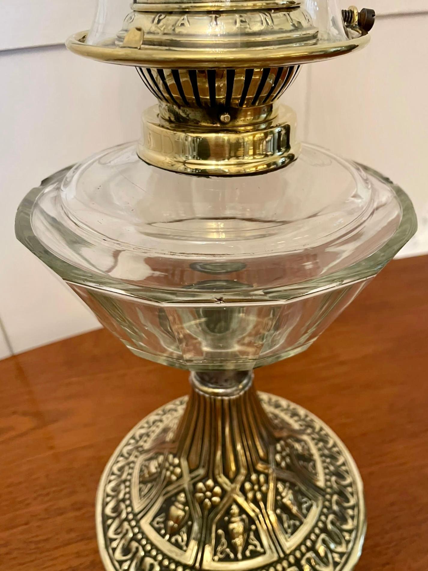Unusual antique Victorian chimneyless ornate oil lamp having a delightful shaped etched glass shade and quality brass burner with a pretty shaped glass font above an ornate brass circular shaped stand. Small superficial chips to the back of the