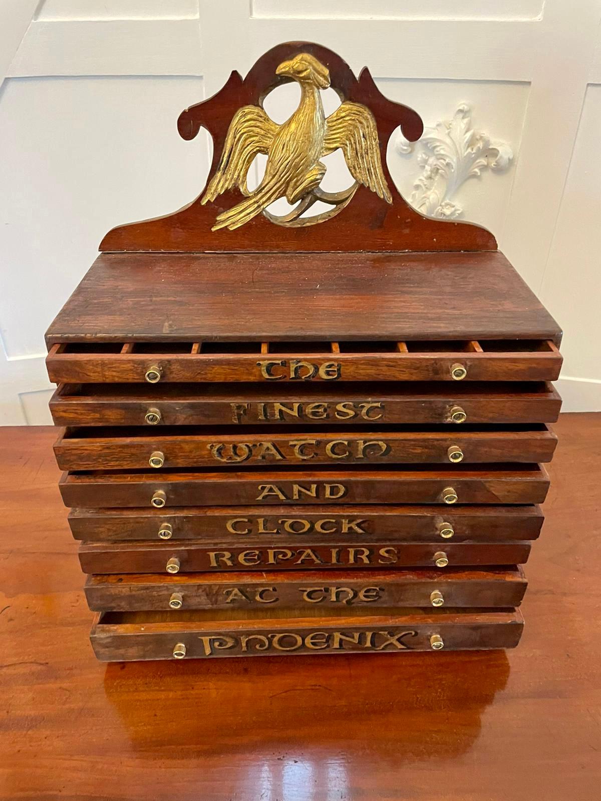 Unusual antique Victorian mahogany watch and clock repairer’s chest having a shaped gallery with a carved gilded phoenix to the centre above eight hand painted drawers displaying the words ‘The Finest Watch and Clock repairs's A C the Phoenix’ in
