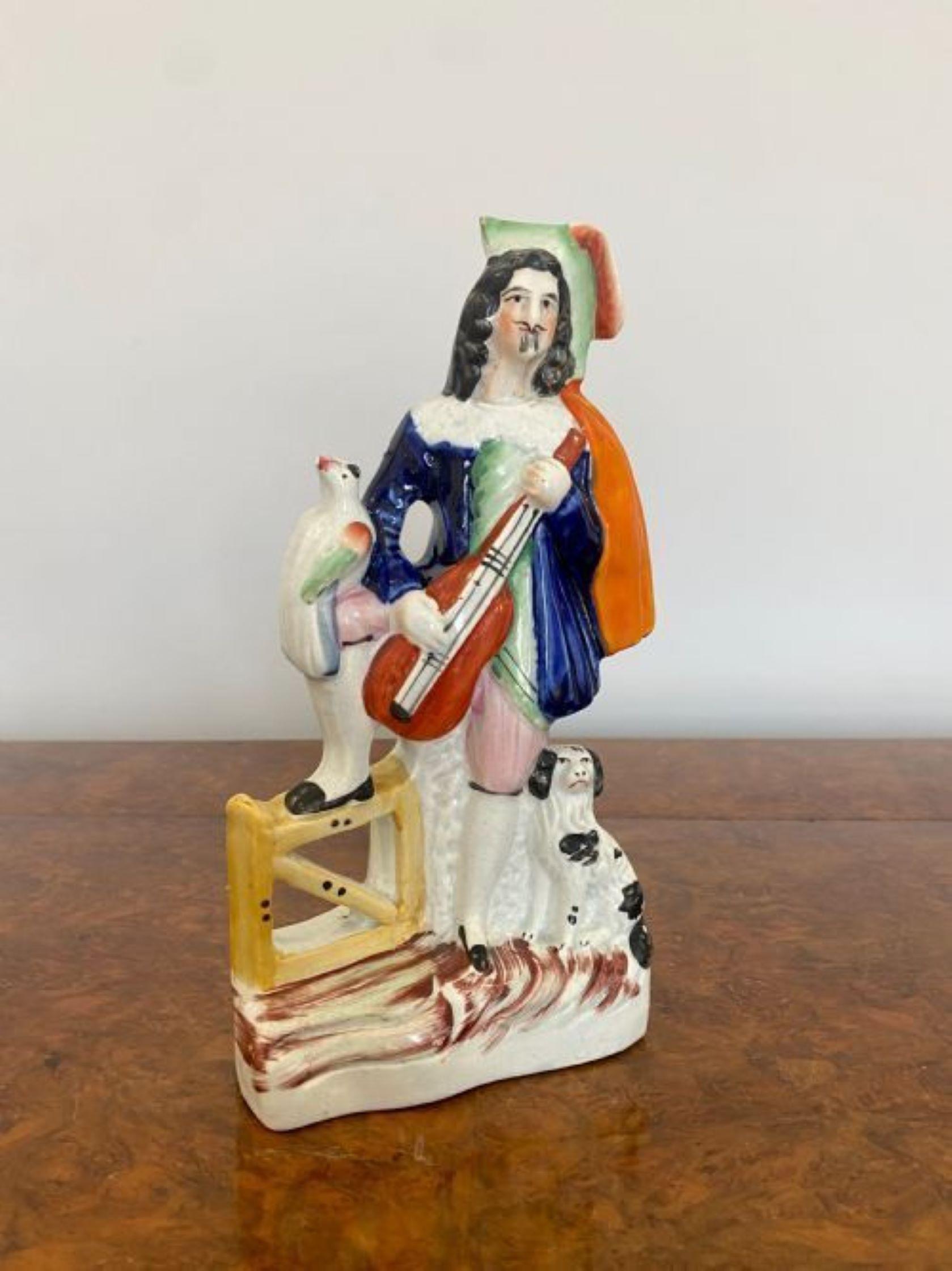 Unusual antique Victorian Staffordshire figure of a gentleman holding a musical instrument with his dog and bird by his side in wonderful period clothing in blue, red, green, black and white colours.