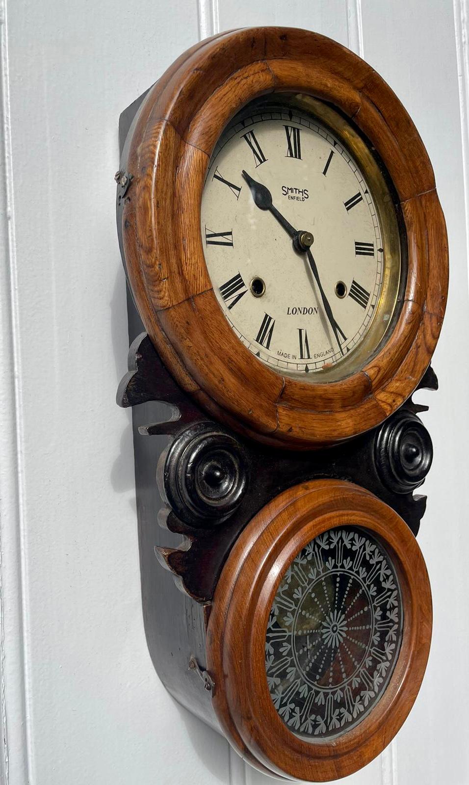 Unusual antique Victorian walnut and ebonised wall clock having a round painted dial with an eight day movement striking on the hour and half hour, unusual shaped case with two round moulded doors and a shaped ebonised supports. 

Measures: H 49cm