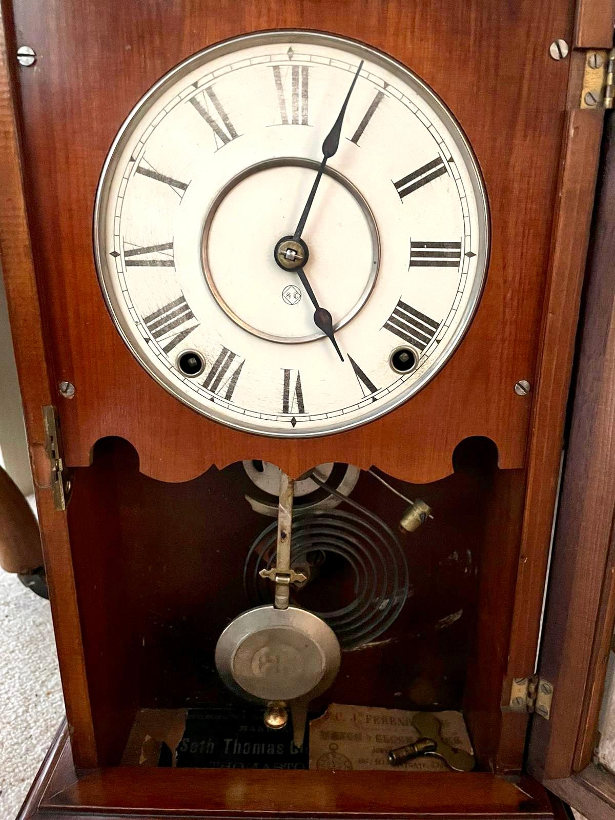 Unusual antique Victorian walnut mantel clock by Seth Thomas having a quality turned gallery top, moulded door with original glass and standing on a plinth base. It boasts a white enamel dial with original hands and an eight day striking movement