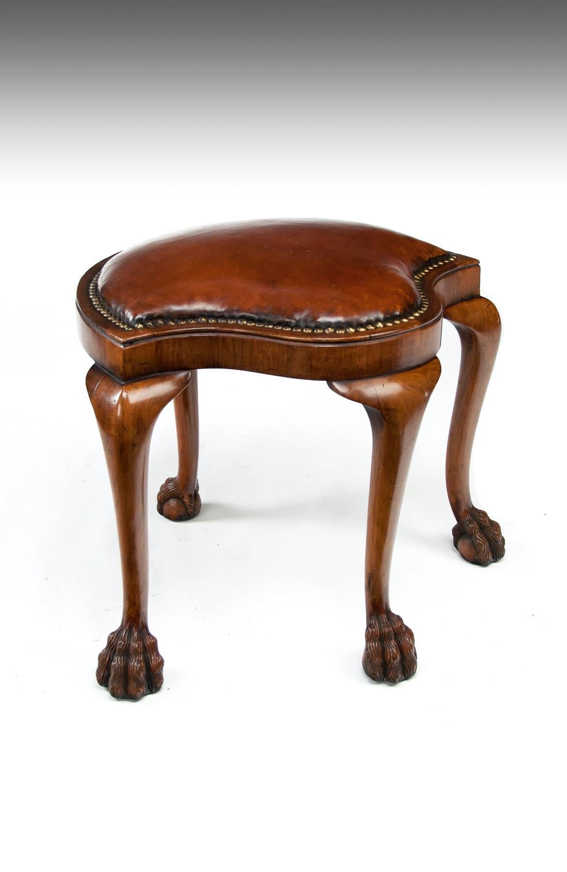 A very unusual antique walnut shaped dressing stool with leather upholstered seat, circa 1920.

This very nice and unusual shaped stool is constructed from solid walnut having a crescent shaped back and serpentine front. The top has a recently