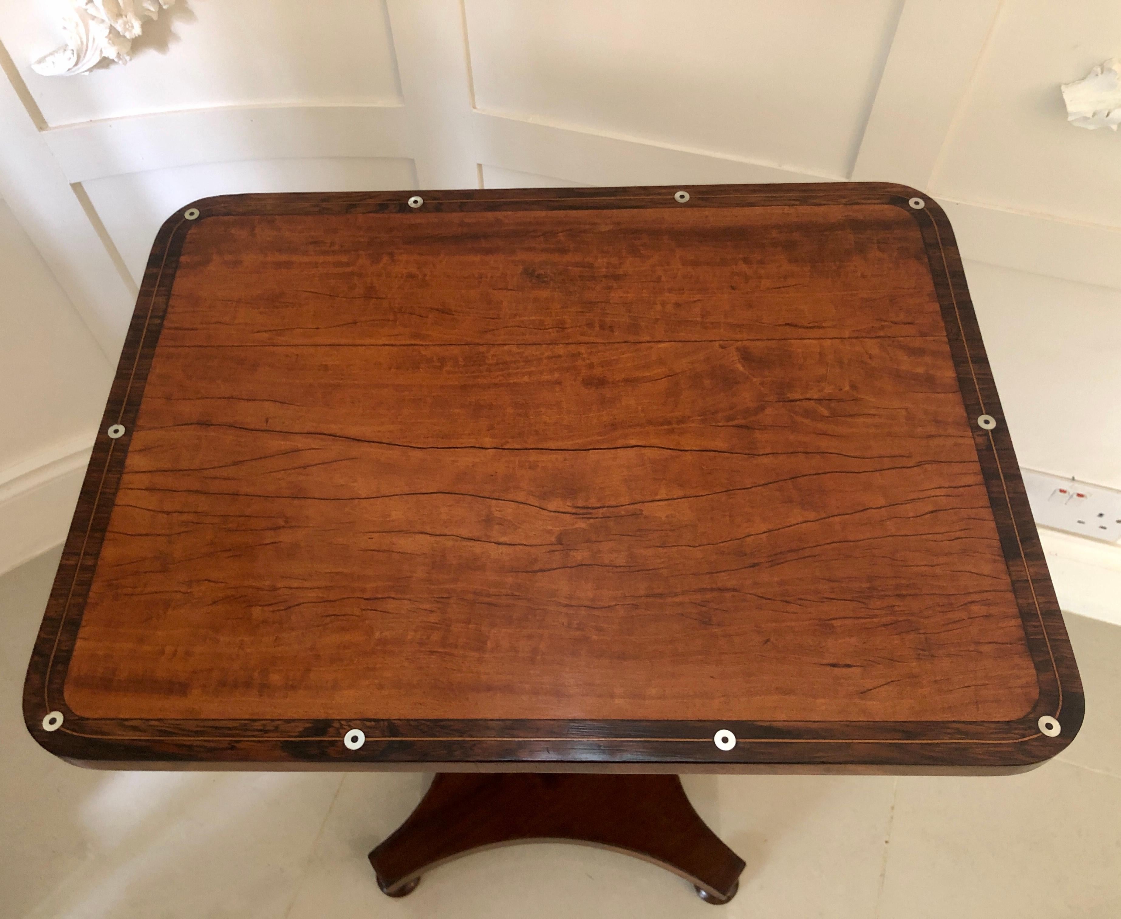 Unusual antique William IV satinwood inlaid lamp table having a lovely quality cross-banded satinwood top with inlay design and shaped rosewood frieze. It is supported by a shaped turned column and raised on an elegantly shaped mahogany platform and
