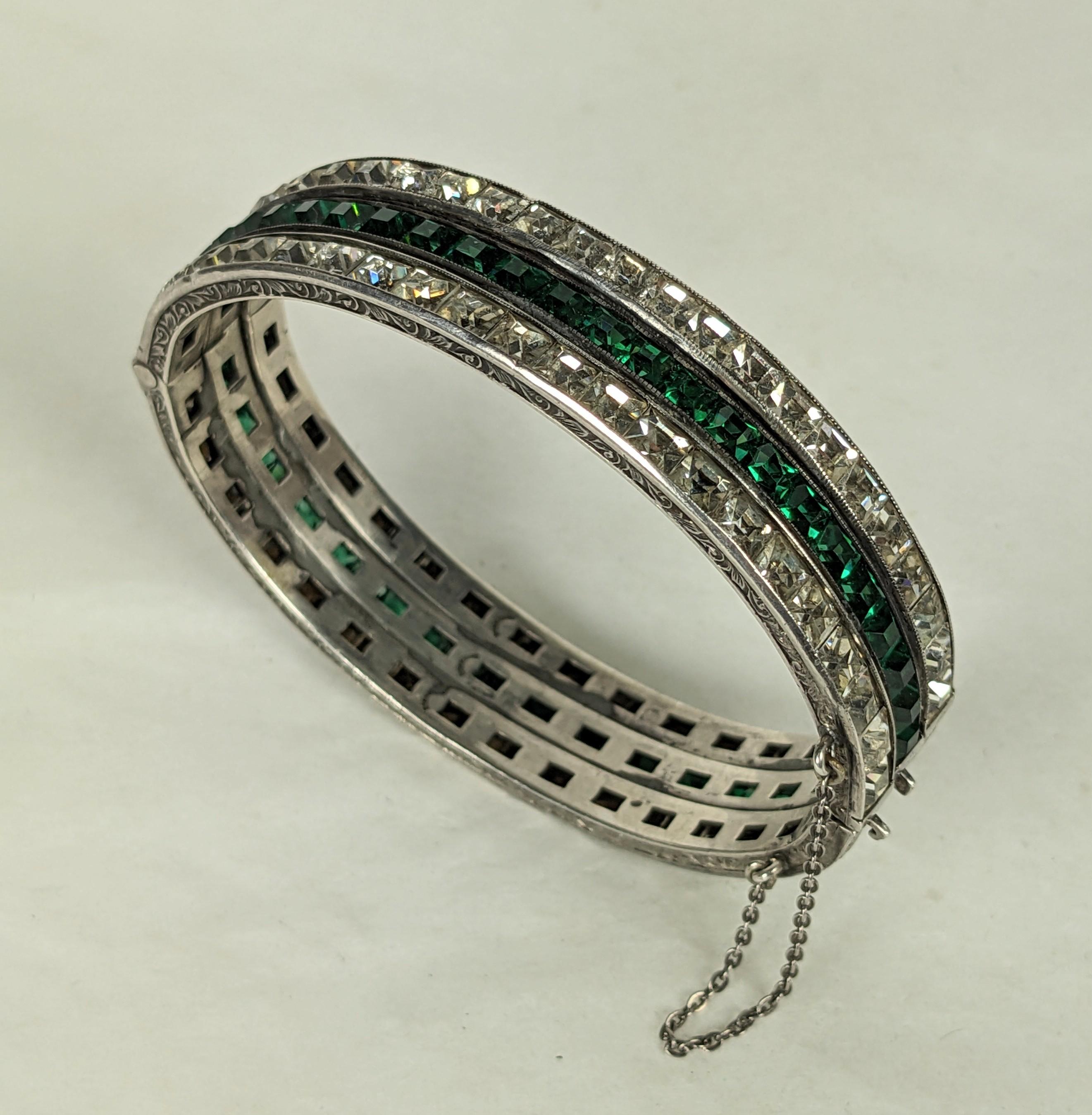 Unusual Art Deco Channel Set Bangle from the 1930's. A series of 3 identical sterling bangles in crystal and emerald were soldered together to form one wider bangle in the period. Very well done, not noticeable that was 3 bangles.
There are 3 clasps