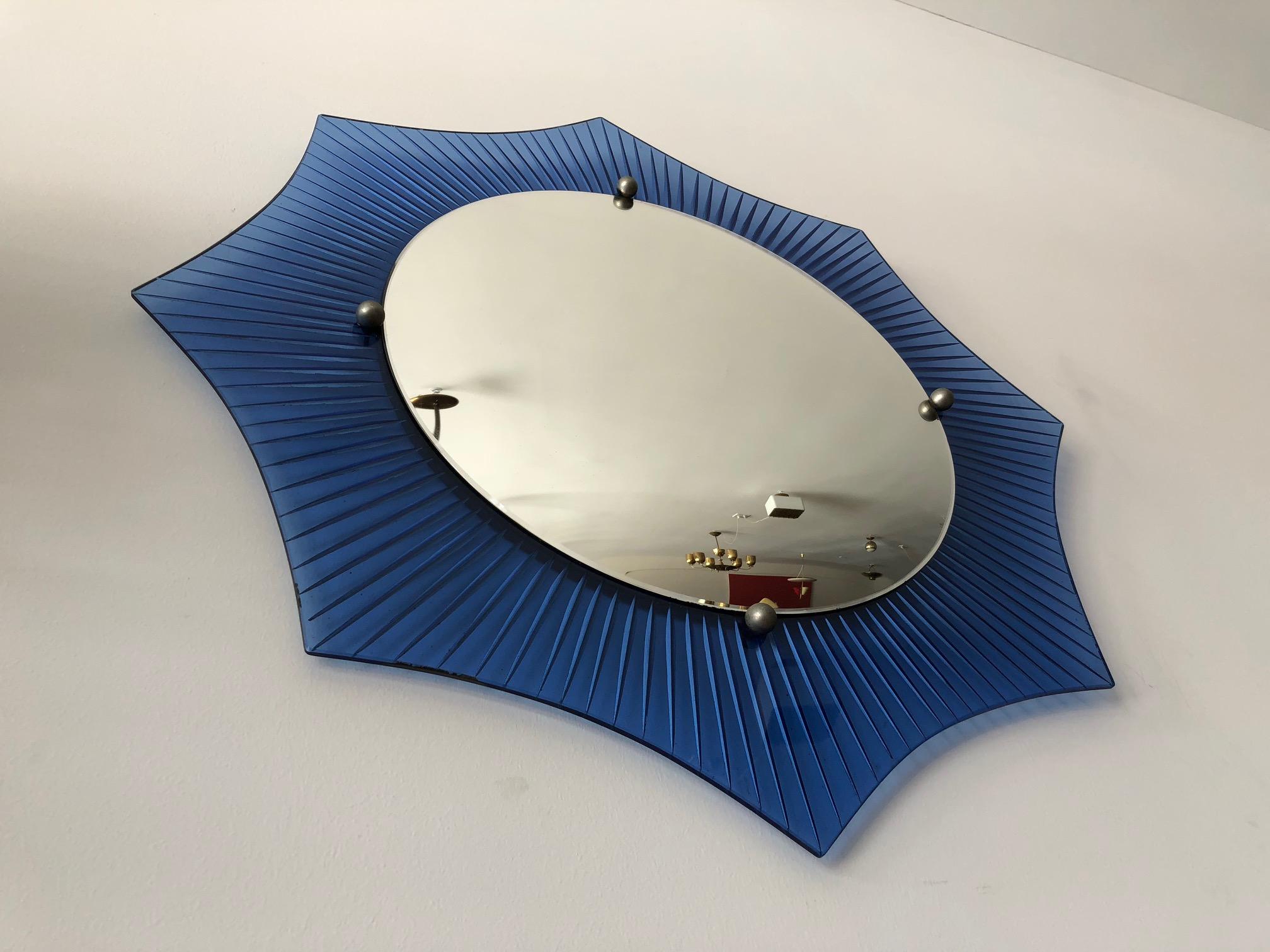 An unusual American Art Deco mirror, circa 1930s. Etched and grooved cobalt radiating lines, convex mirror, eight sided with plated steel balls. Measures: 29.75