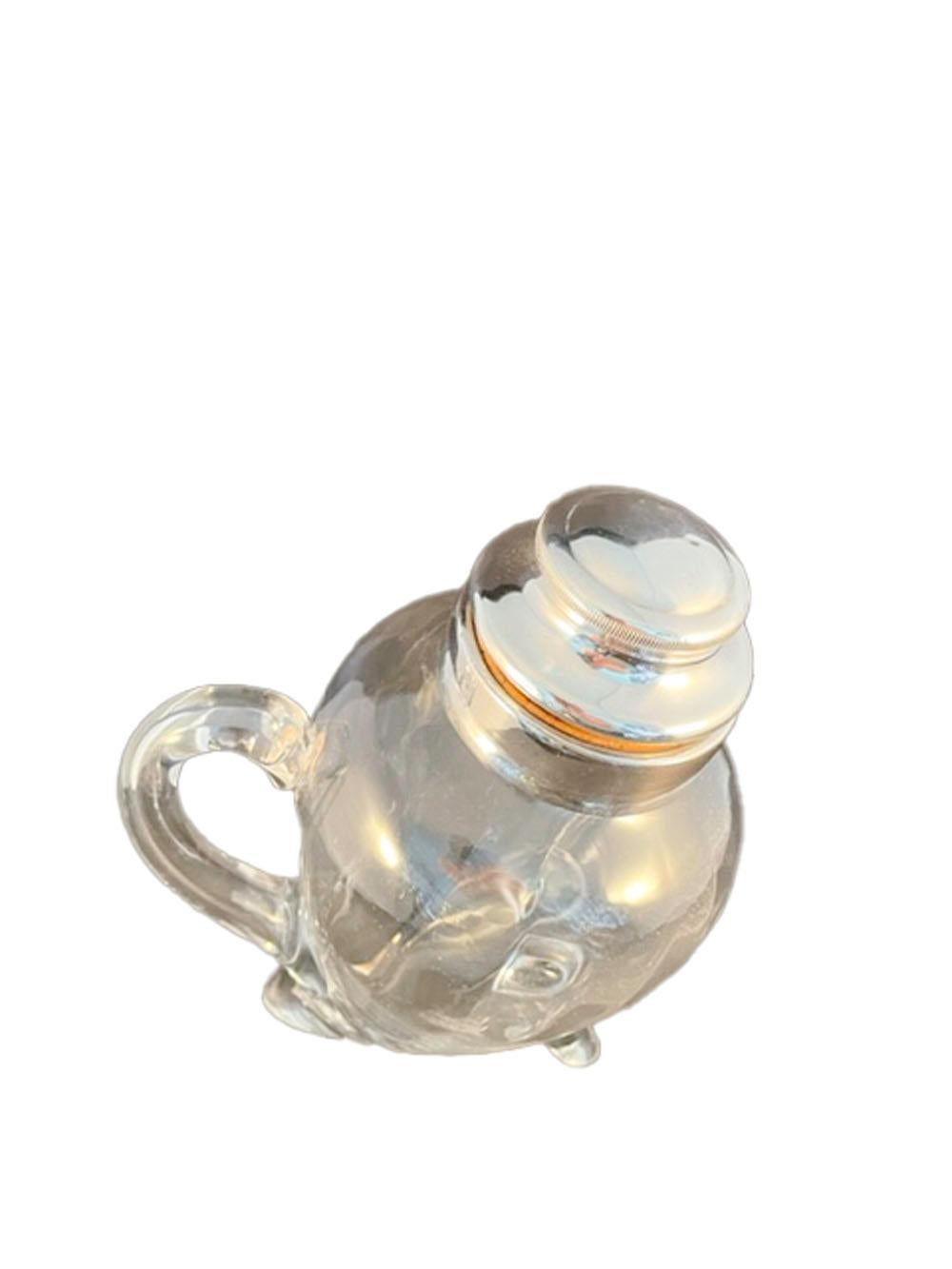 Unusual blown glass cocktail shaker of 'duck-body' form with applied handle and 'feet'. The shakers mouth with a silver plate collar fitted with a silver plate and cork stopper, the interior of the stopper with an integral icebreaker/muddler.