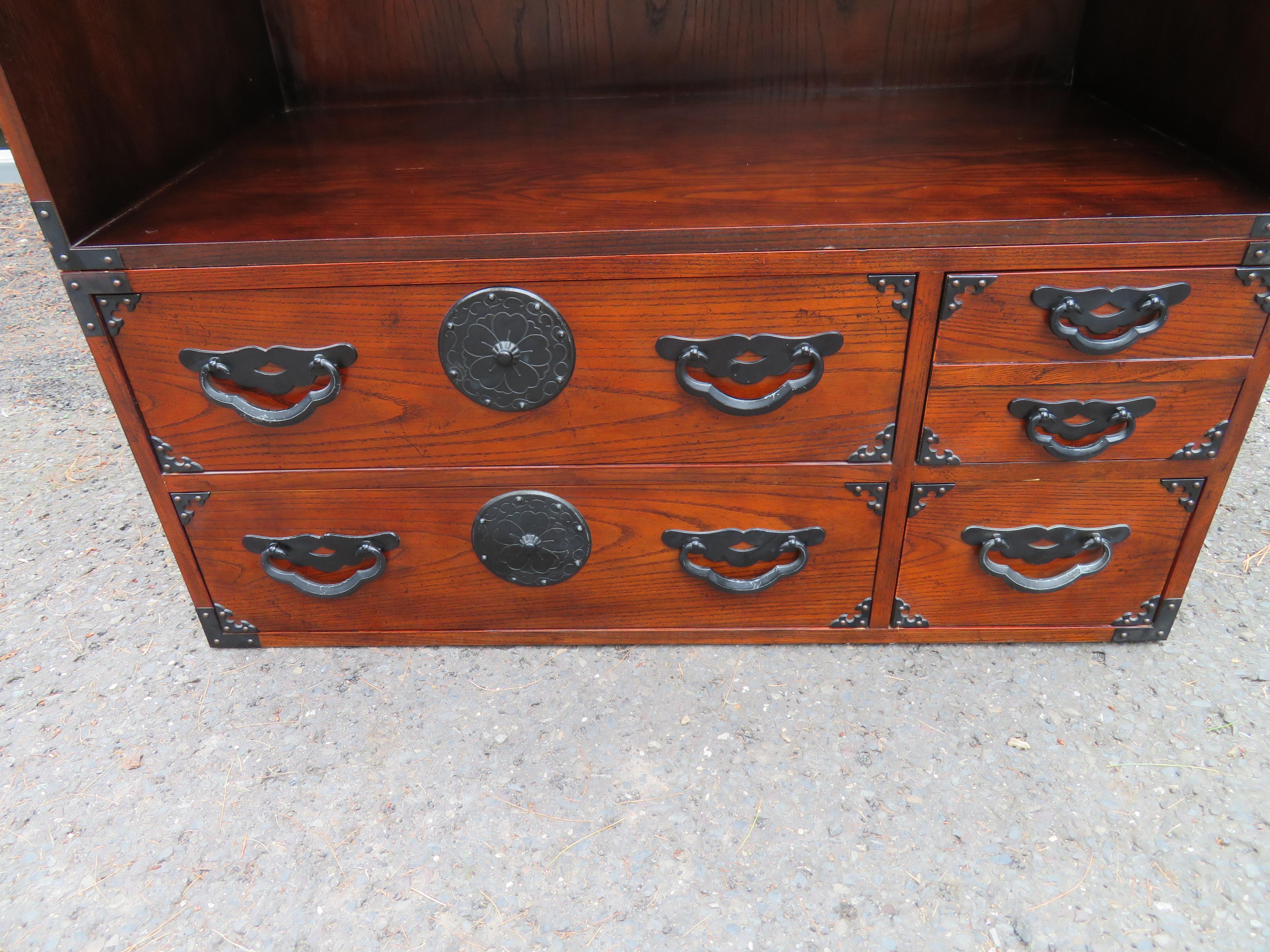 Unusual Baker Chinoiserie style 2-piece modular bookcase chest.  The top shelving unit sits on top of a Tansu-style 4 drawer chest.  We love the blackened iron hardware along with the slightly distressed dark oak finish.  This set measures 59.25