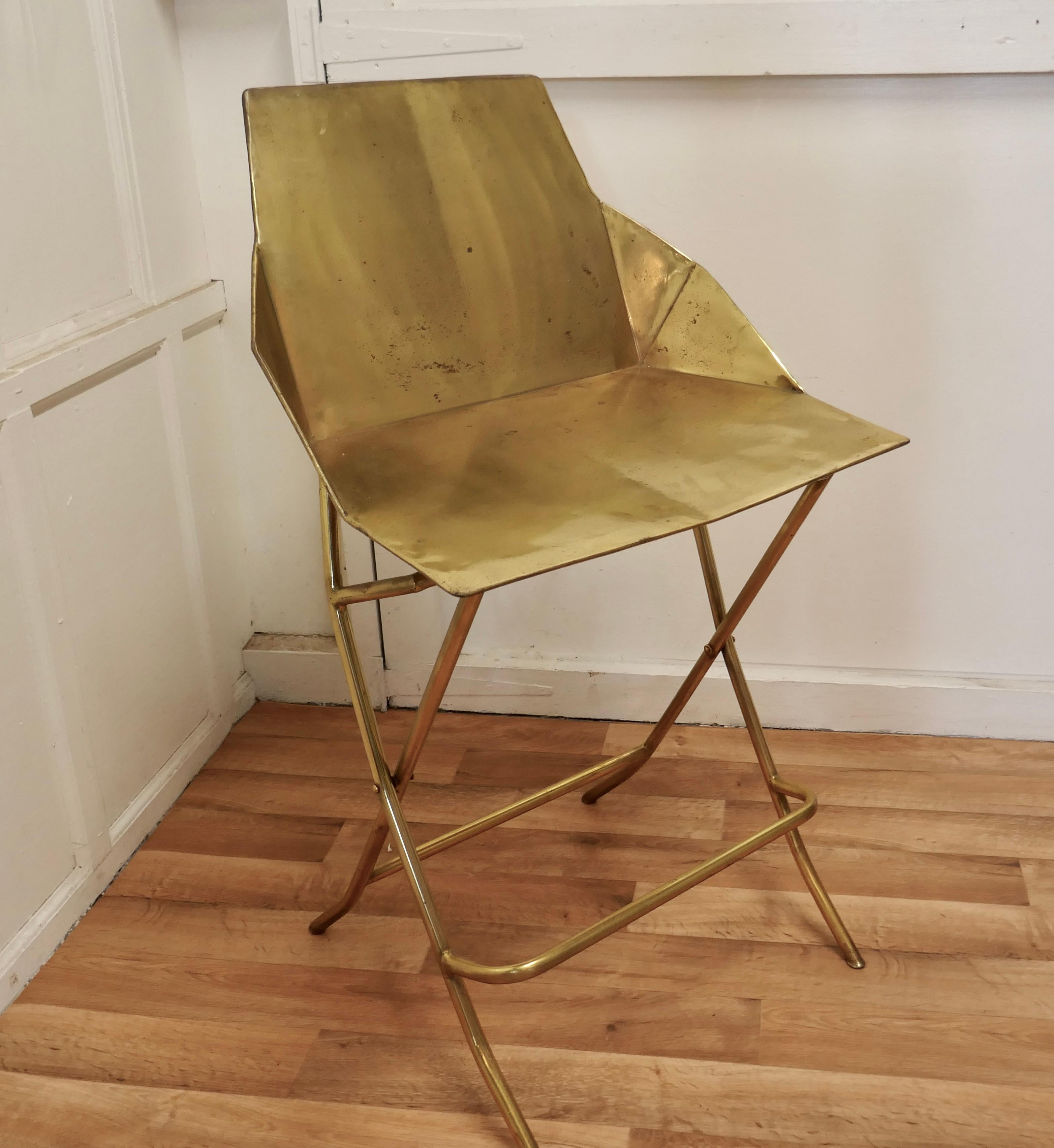 Unusual brass adjustable designer chair.

A very unusual piece, this chair is all made in brass, the seat can be set to 2 different heights either to suit a Bar or a Table ( very handy for kitchen use)
The chair has a foot support rail, a flat