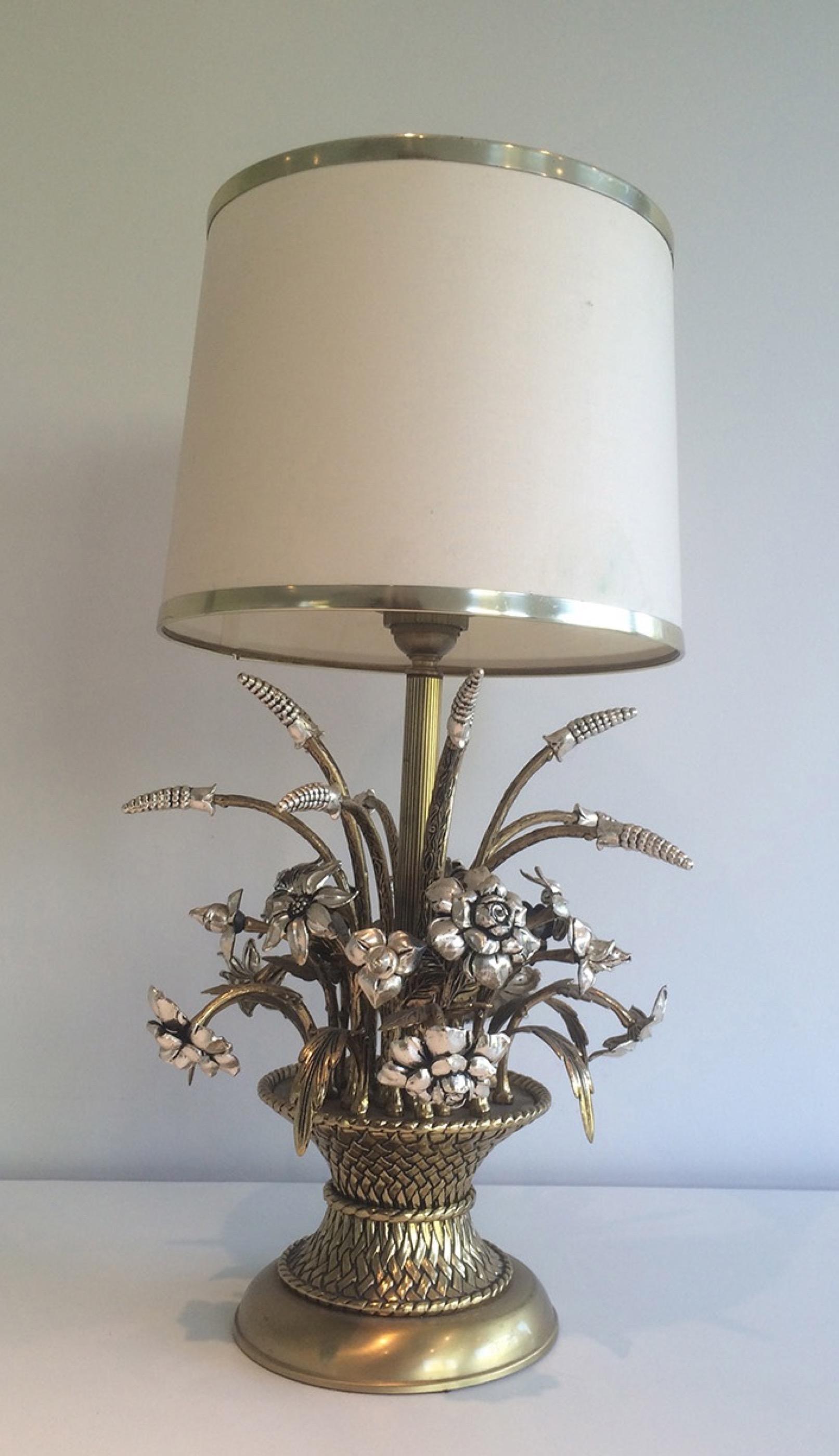 This very nice decorative table lamp is made of brass and silver. It represents a charming bouquet of flowers in a basket. This is a French work, circa 1960.