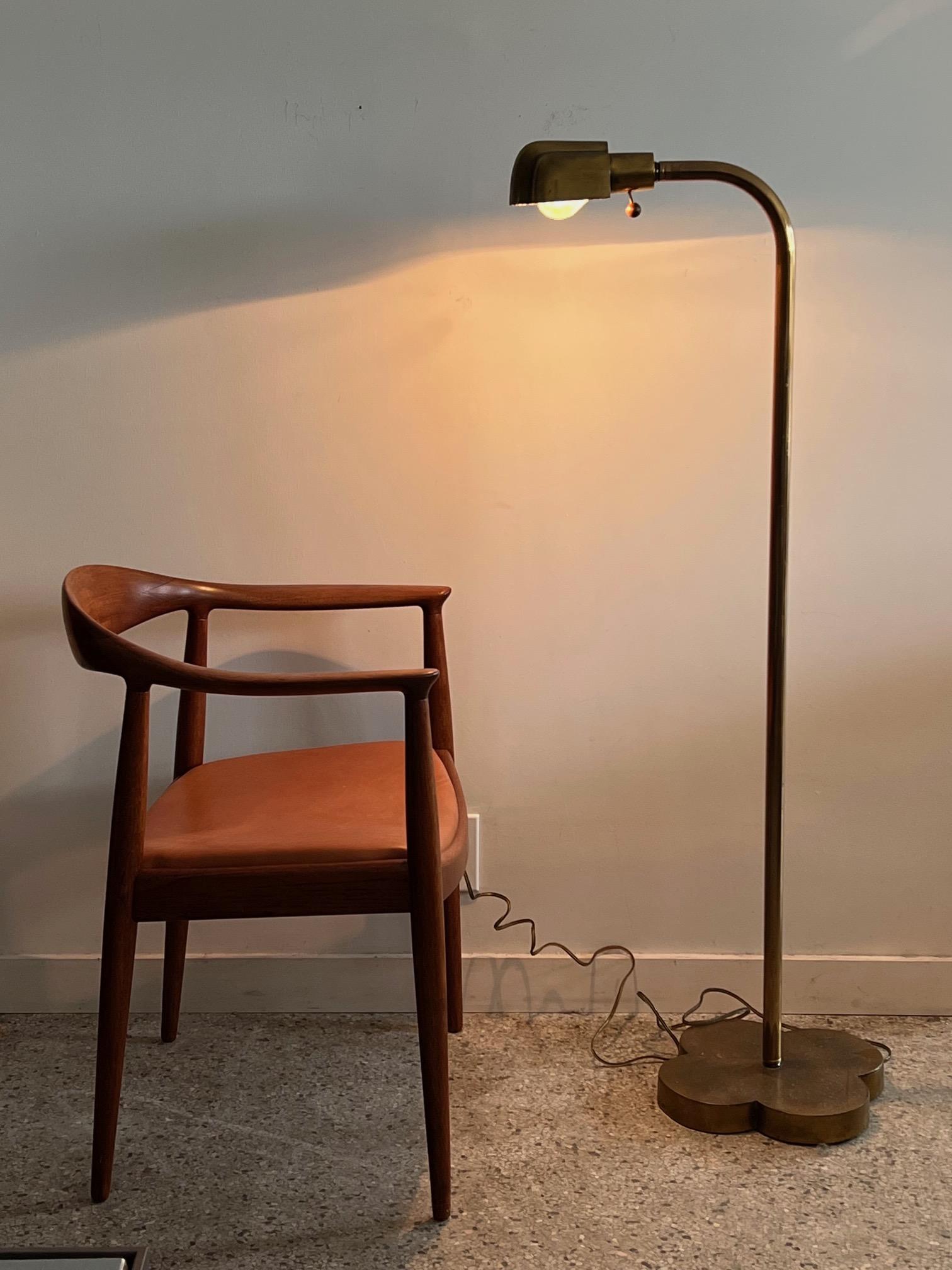 Unusual patinated brass reading/floor lamp with a heavy clover shaped base. The lamp has a nice aged patina. Two way wood ball switch.