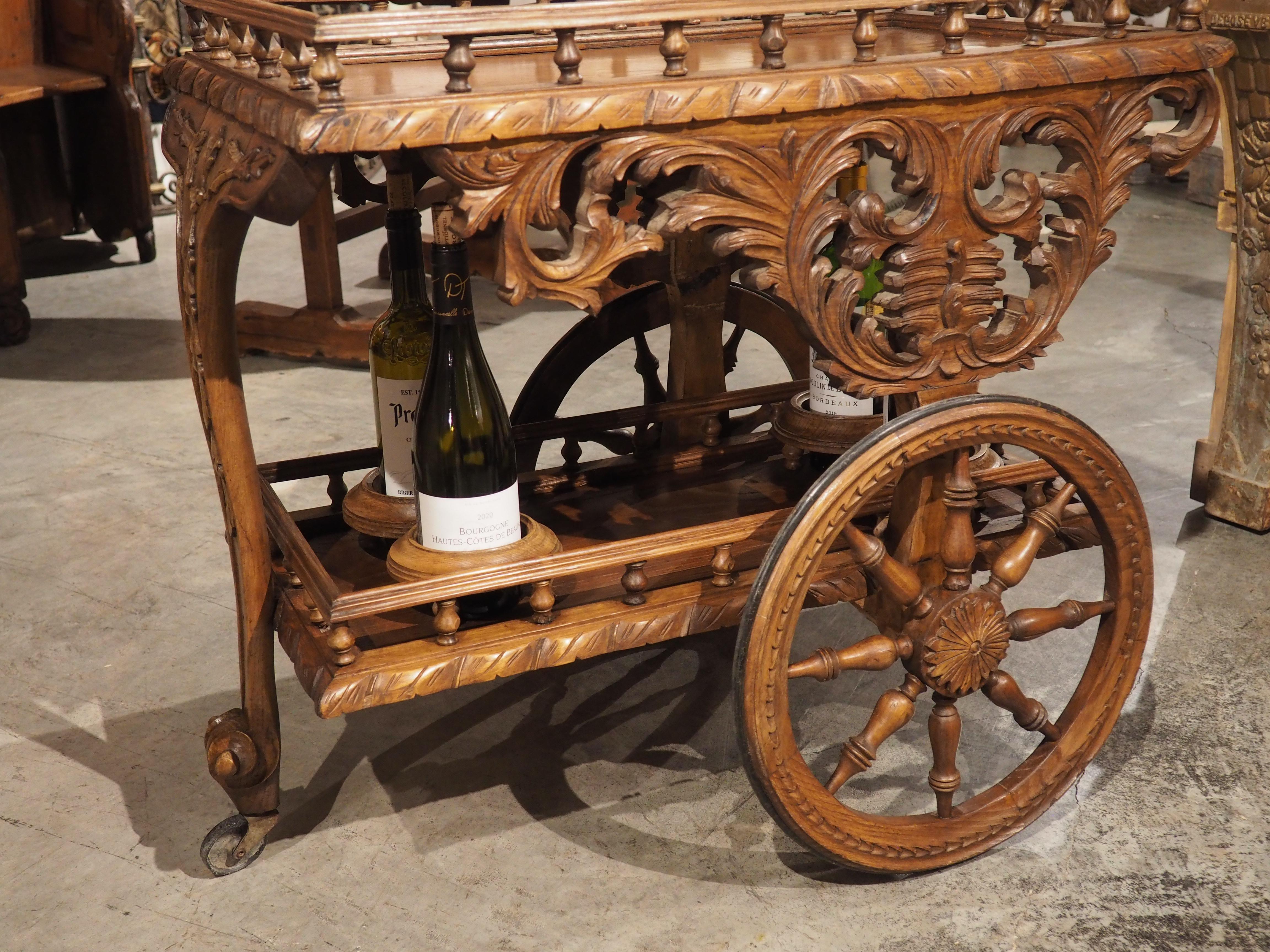 An unusual beverage table from Brittany, France, this bar cart was designed for the utmost portability, traversing via a pair of 16-inch wooden wheels. Typically, bar carts of this age (early 1900s), would be crafted from metal, namely brass or