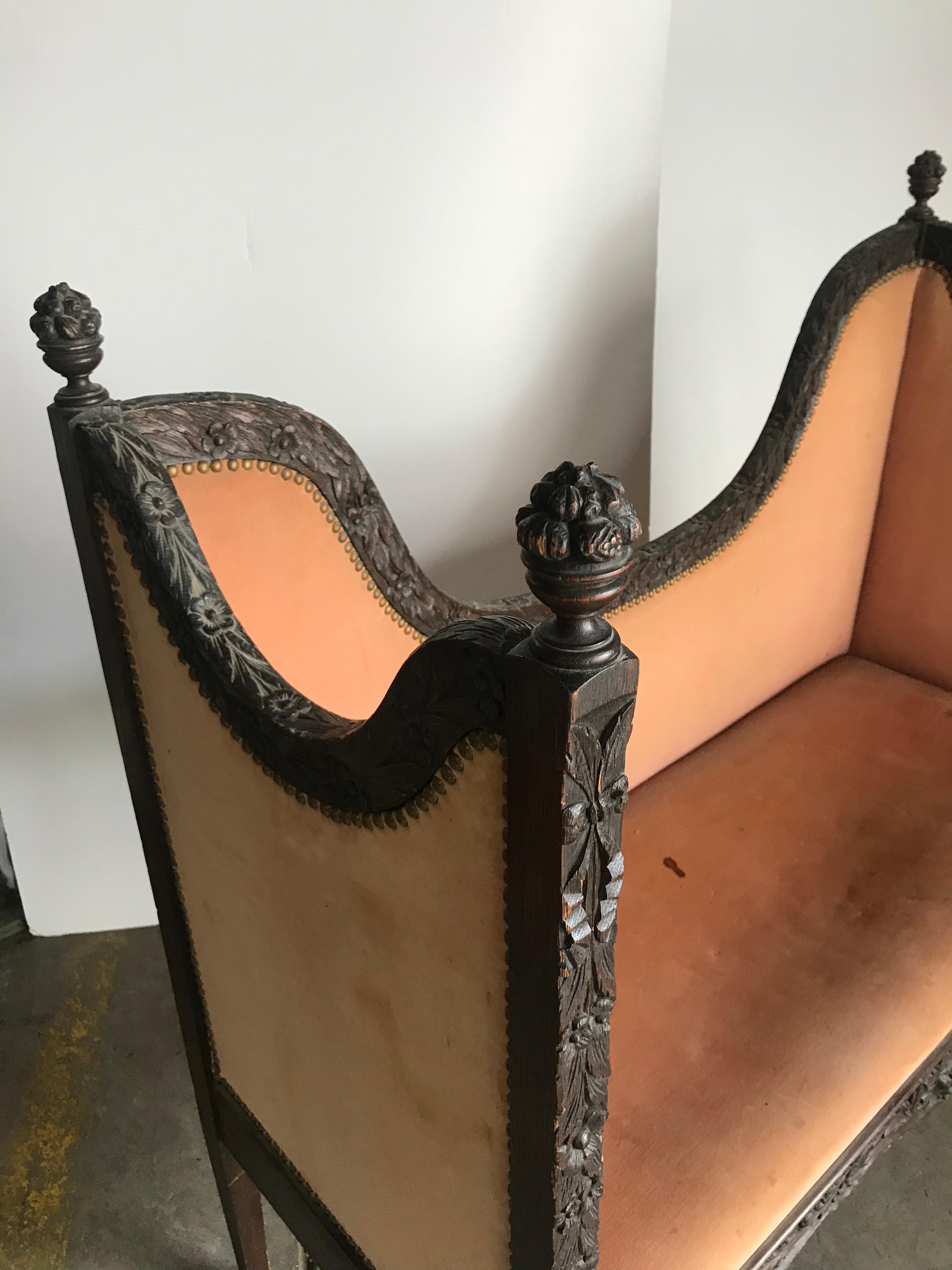 Unusual carved turn of the century settee / loveseat, carver face (center) carved snake motif (legs), carved wood finials, retains original upholstery, in need of restoration.