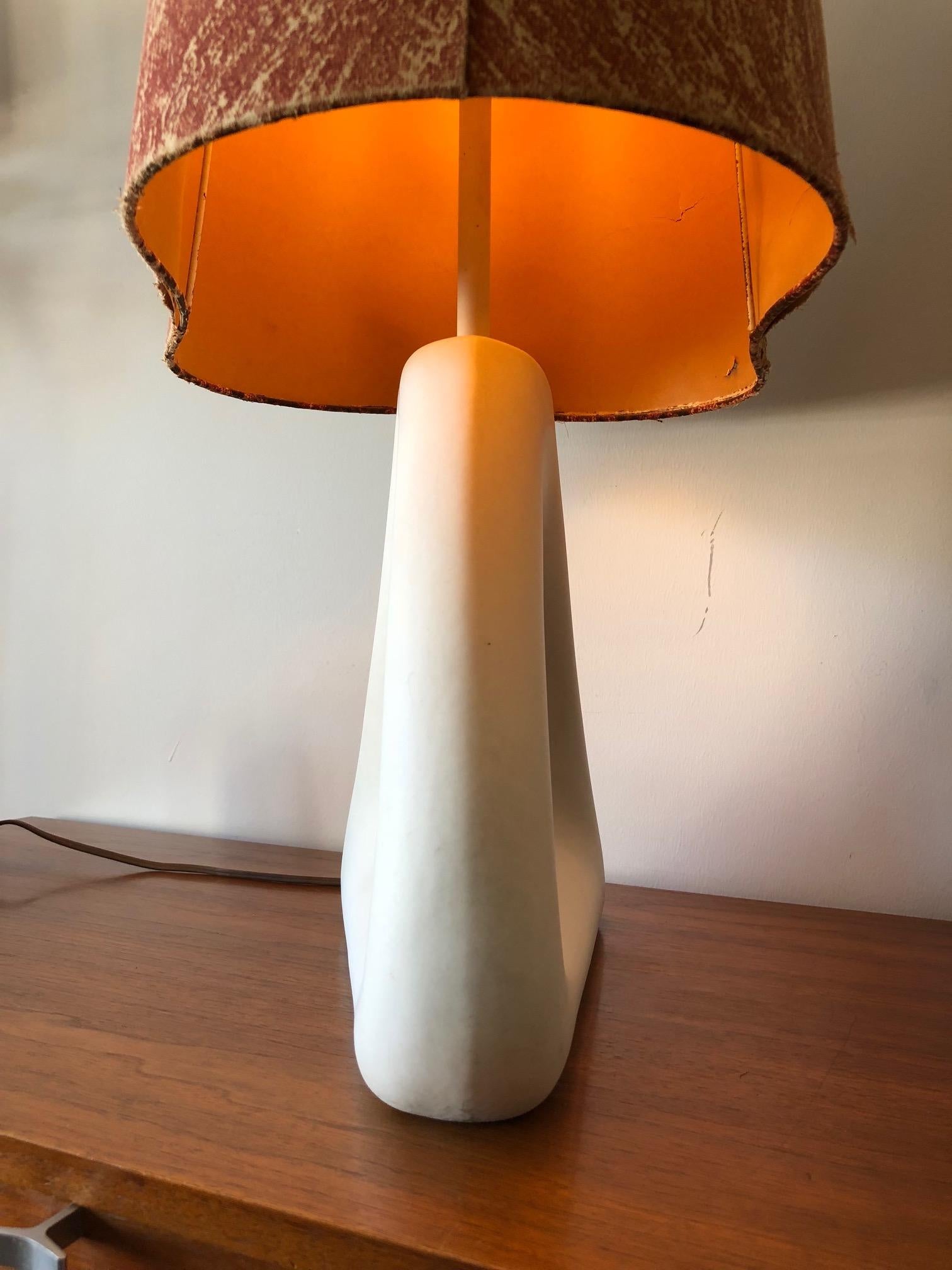 An unusual white ceramic lamp-biomorphic design with rounded cut outs and original shade.