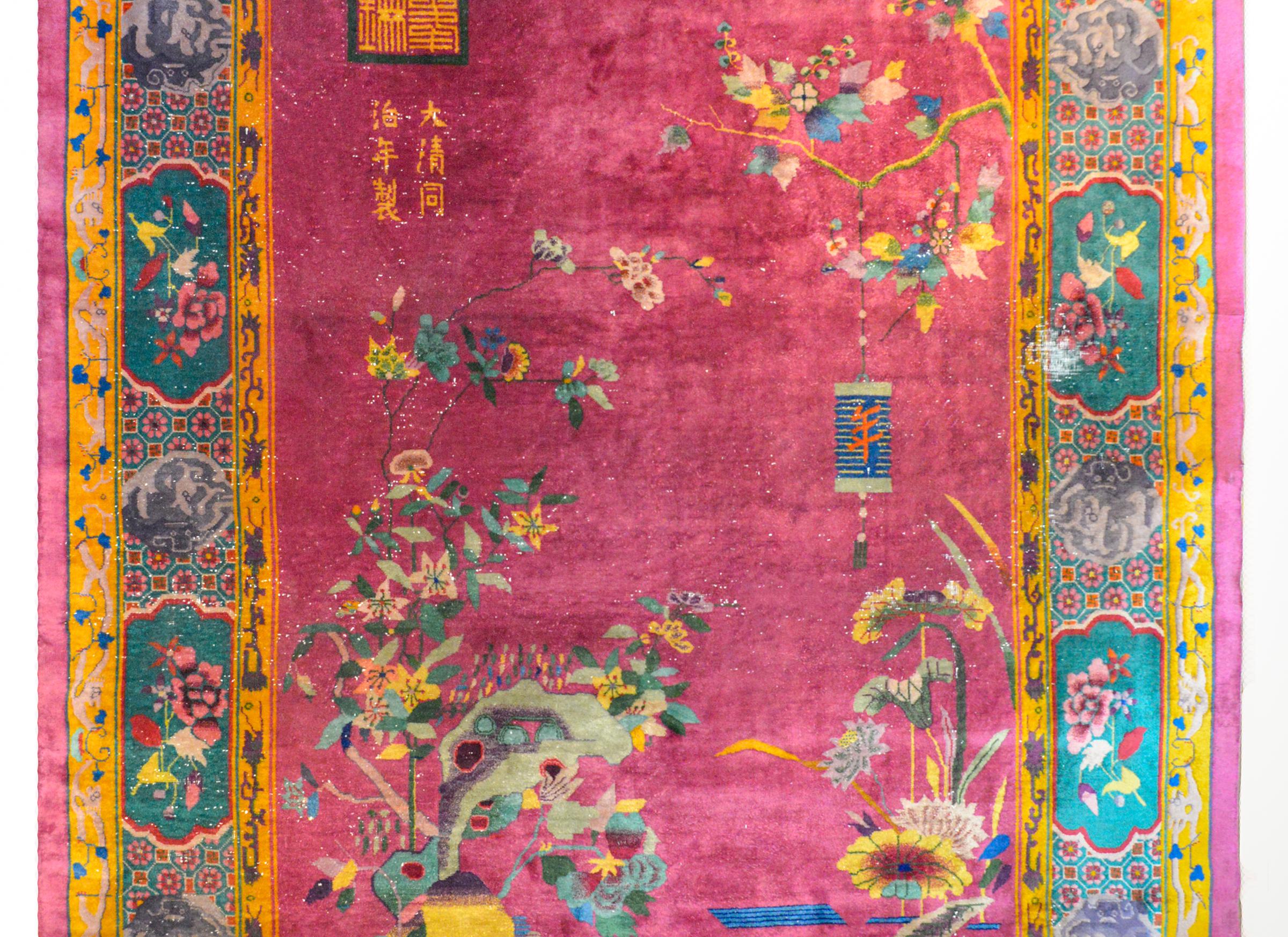 An unusual early 20th century Chinese Art Deco rug with a fuchsia ground surrounded by an unusually patterned border containing several floral cartouches alternating with puffs of billowing clouds with dragons swirling within. Over the field lives a
