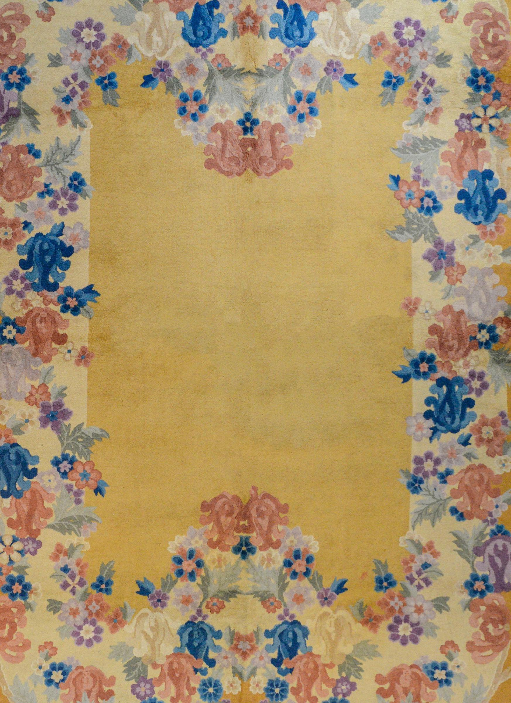 An unusual early 20th century Chinese Art Deco rug with a beautiful, multicolored stylized chrysanthemum and leaf pattern, woven in shaded of indigo, green, pink, and cream colored vegetable dyed wool on a gorgeous gold background.