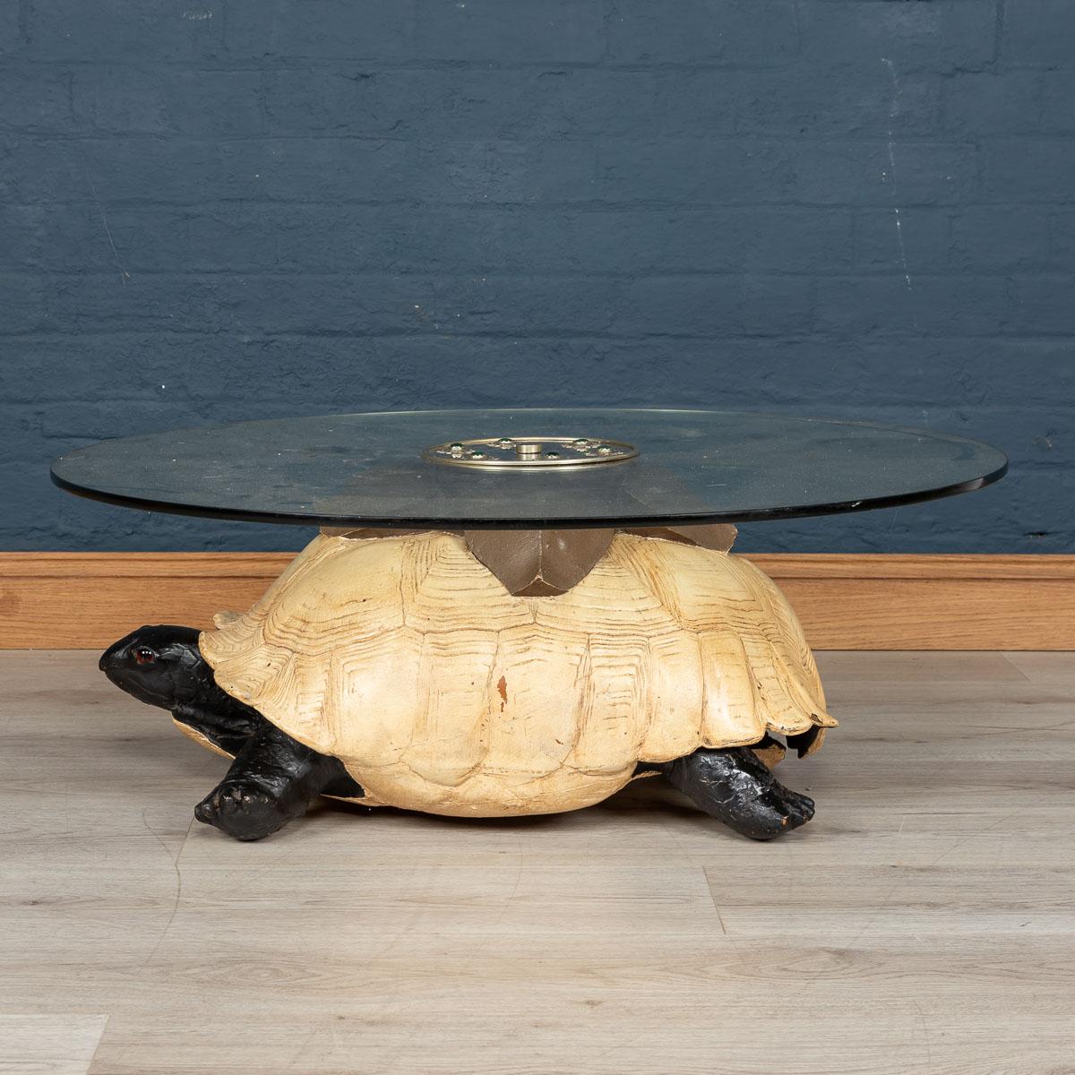 A coffee table by Anthony Redmile, London, circa 1970. The base of the table fashioned from composite painted turtle, the central circular plaque inlaid with hardstone cabochons signed Redmile, London to the centre. Anthony Redmile burst into the