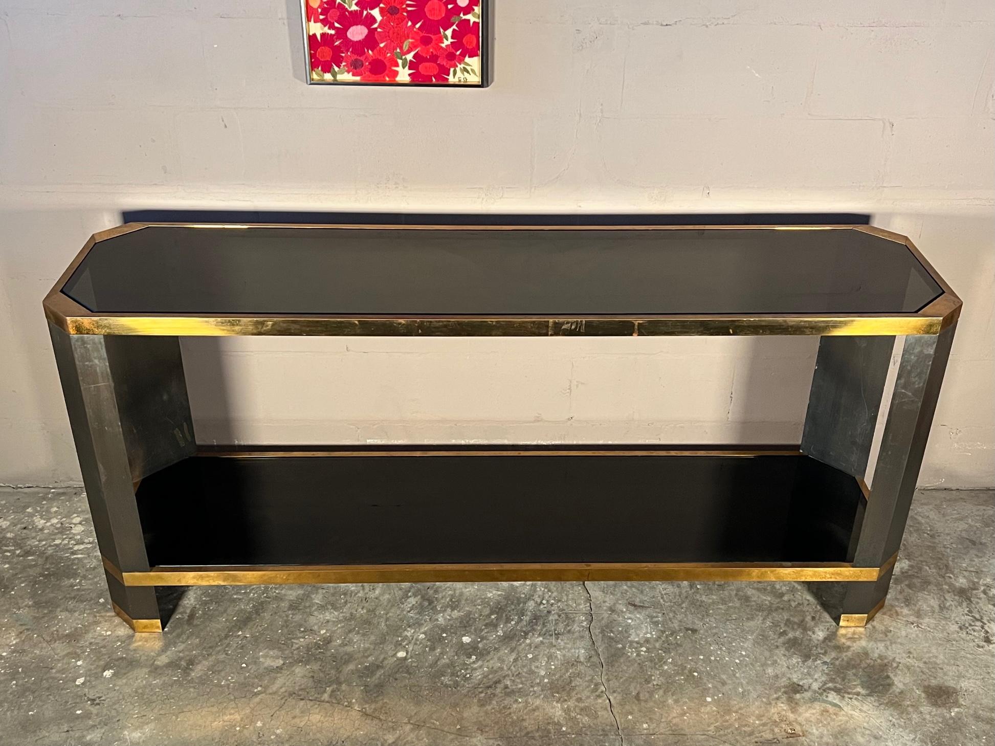 An outstanding console table designed by Ron Seff and custom made in NYC ca' 1970's. Heavy solid brass legs and solid brass machined levelers. The top and lower shelf have a fitted  1