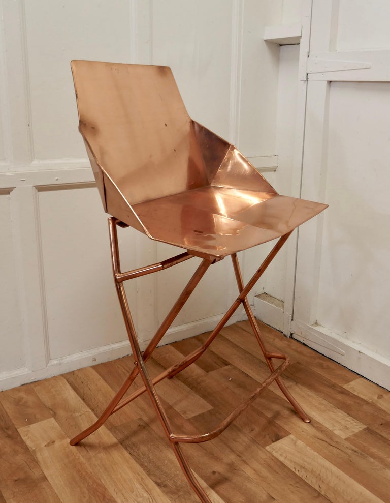 Unusual copper adjustable designer chair

A very unusual piece, this chair is all made in copper, the seat can be set to 2 different heights either to suit a Bar or a Table ( very handy for kitchen use)
The chair has a foot support rail, a flat