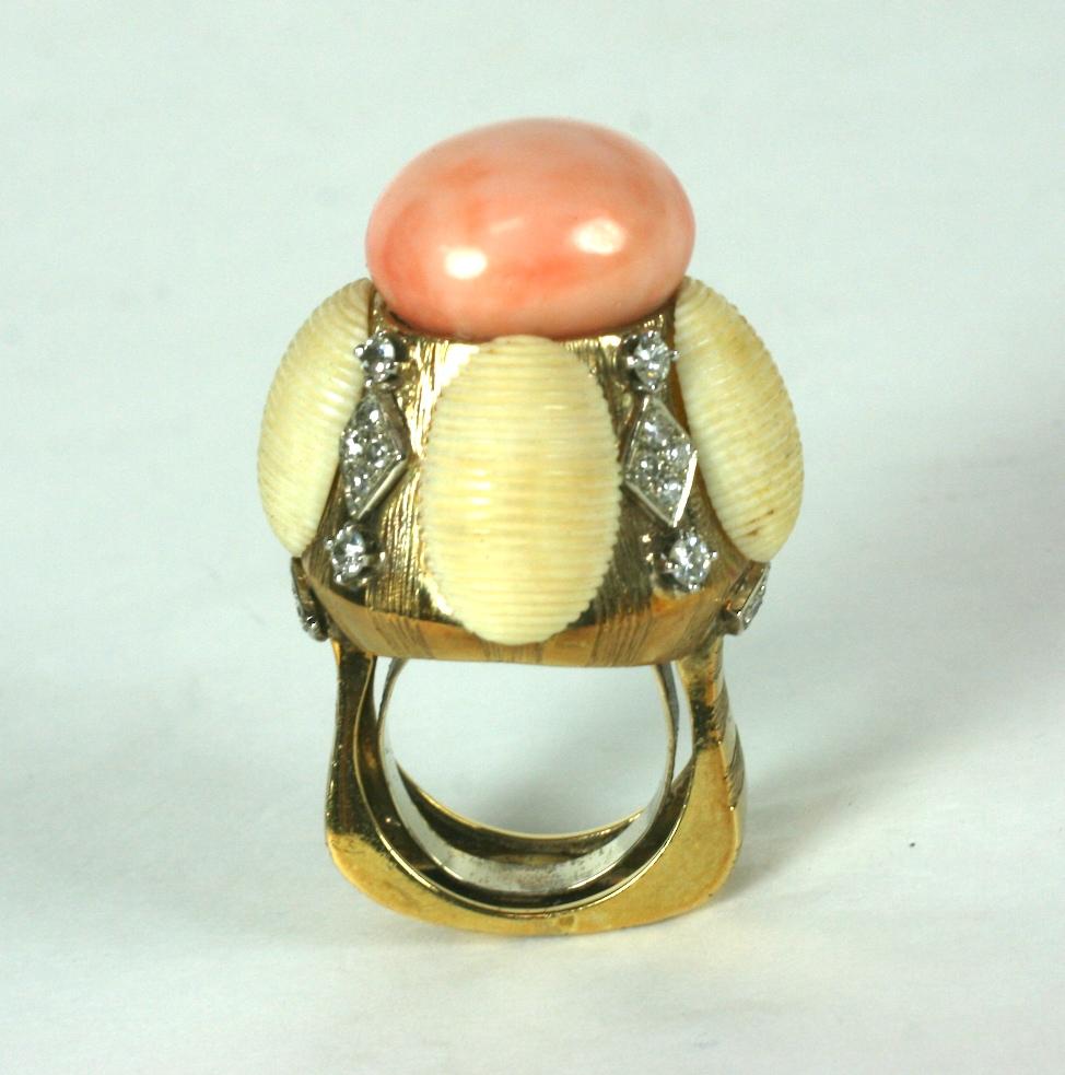 High design Coral and Diamond Domed Cocktail Ring from the 1970's in heavy 18k gold. A large creamy coral cabochon (18mm) caps the high dome sculptural design which is flanked by diamond accents and scored bone oval panels. 
The gold is hand