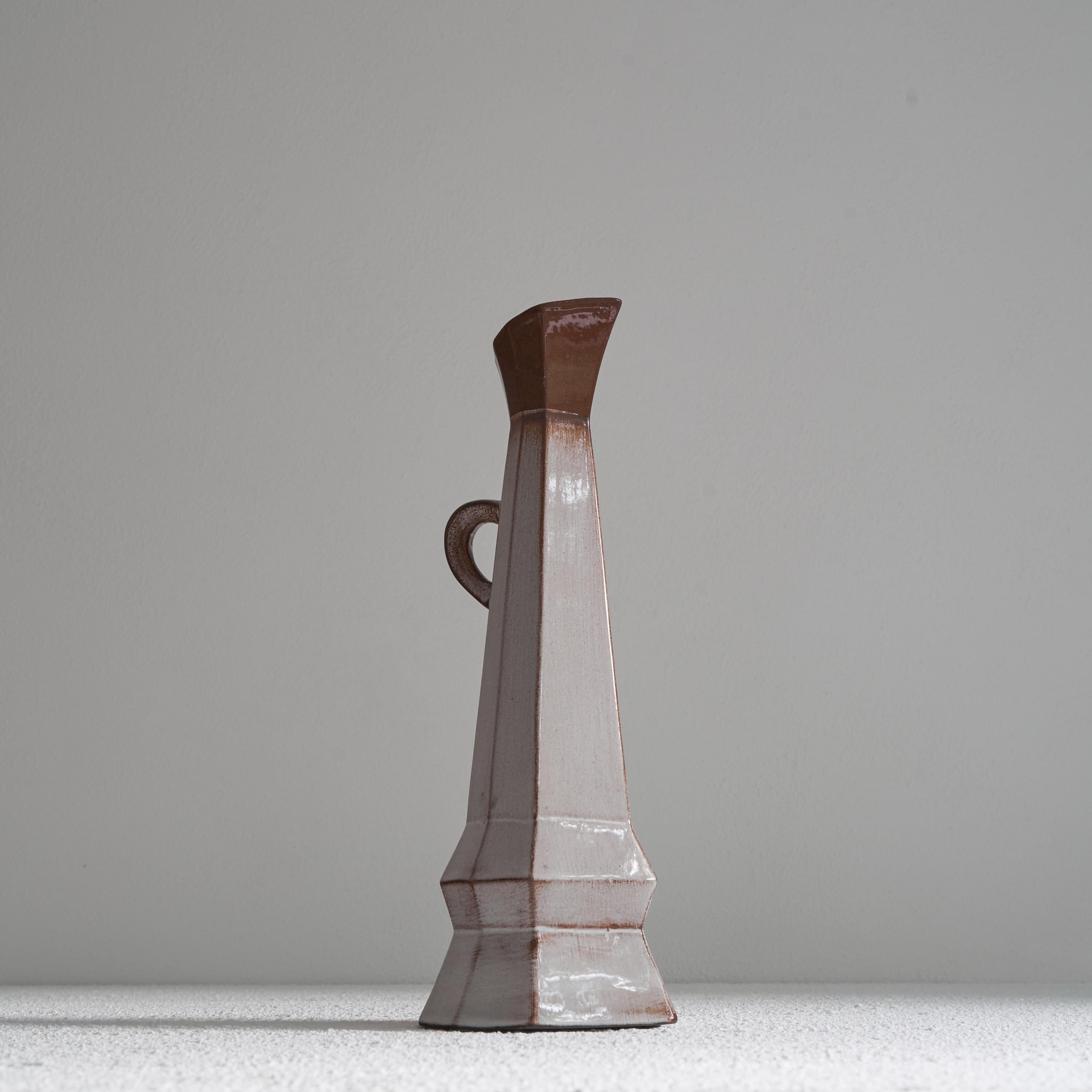 Vase-pichet inhabituel en poterie du Studio cubiste. Milieu du XXe siècle. 

Vase-pichet très inhabituel et asymétrique en poterie de studio avec une glaçure colorée attrayante. Des formes cubistes intéressantes et des angles aigus lui confèrent