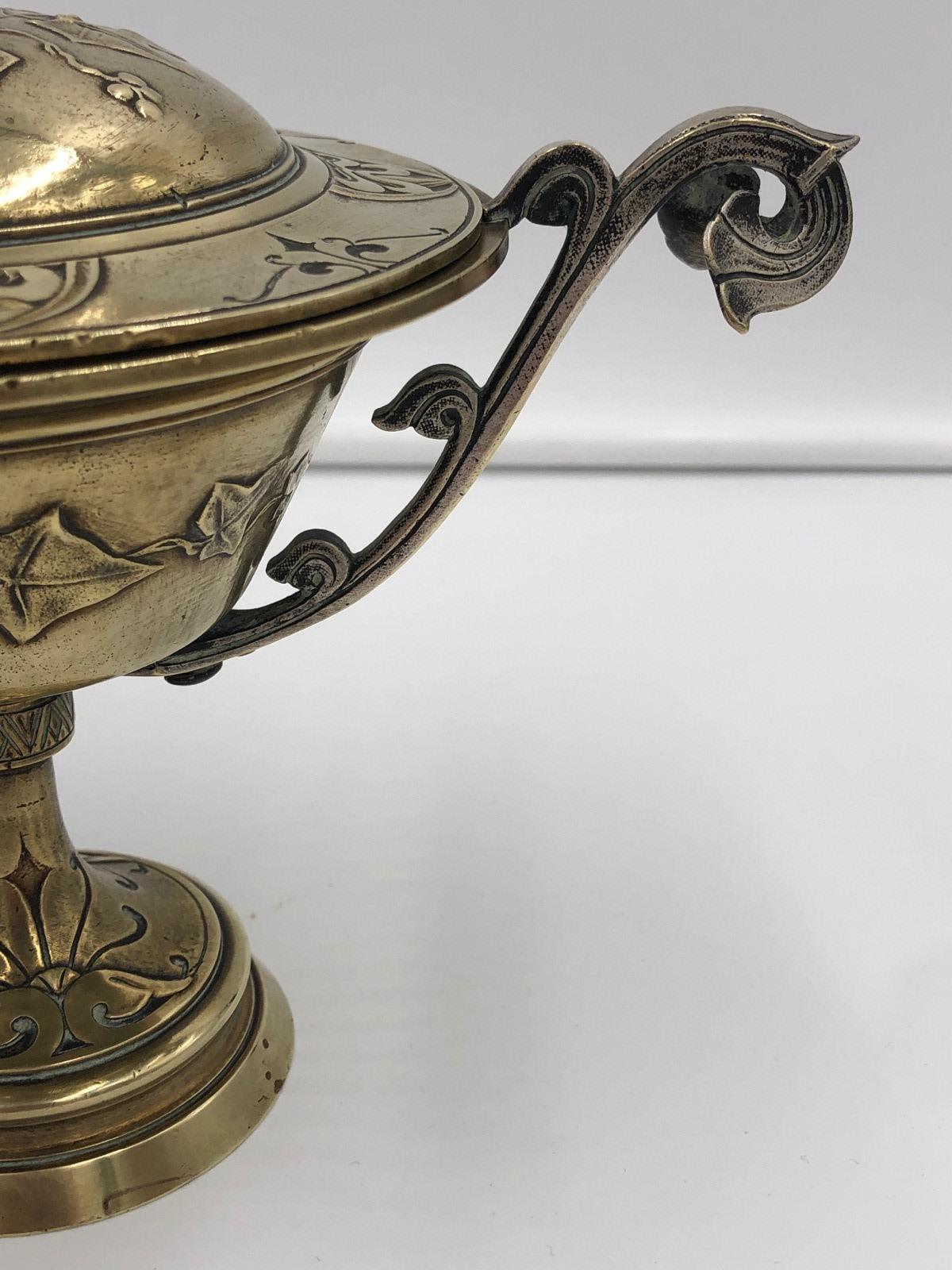 Insolita urna decorativa in ottone antico con coperchio, con un grazioso disegno di viti e foglie su tutta la superficie e manici decorati, in buone condizioni.