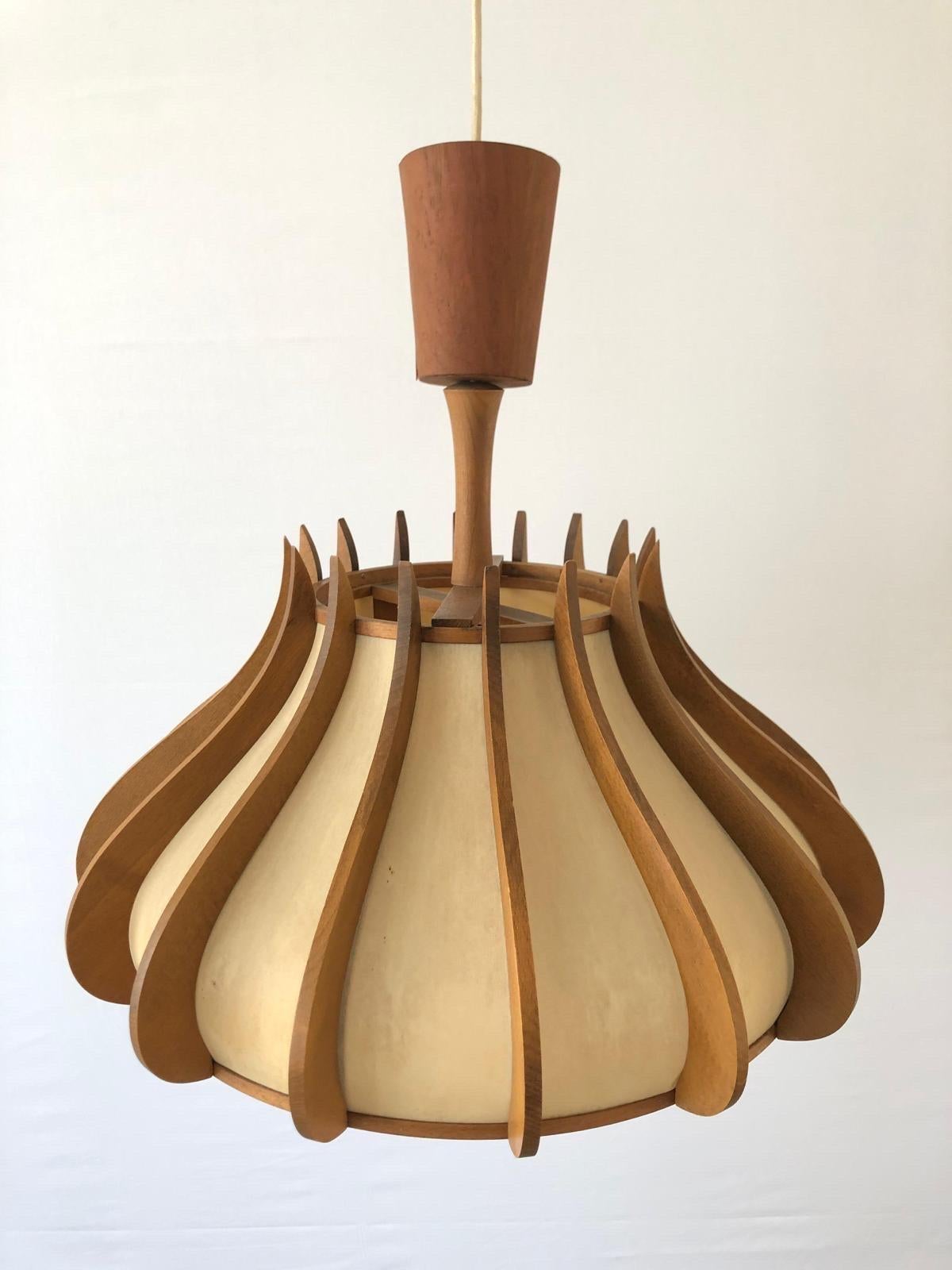 Unusual design Wood and Plastic Paper Large Pendant Lamp, 1960s, Germany

Elegant and minimal design hanging lamp

Lampshade is in good condition and very clean. 
This lamp works with E27 light bulb. Max 100W
Wired and suitable to use with 220V and