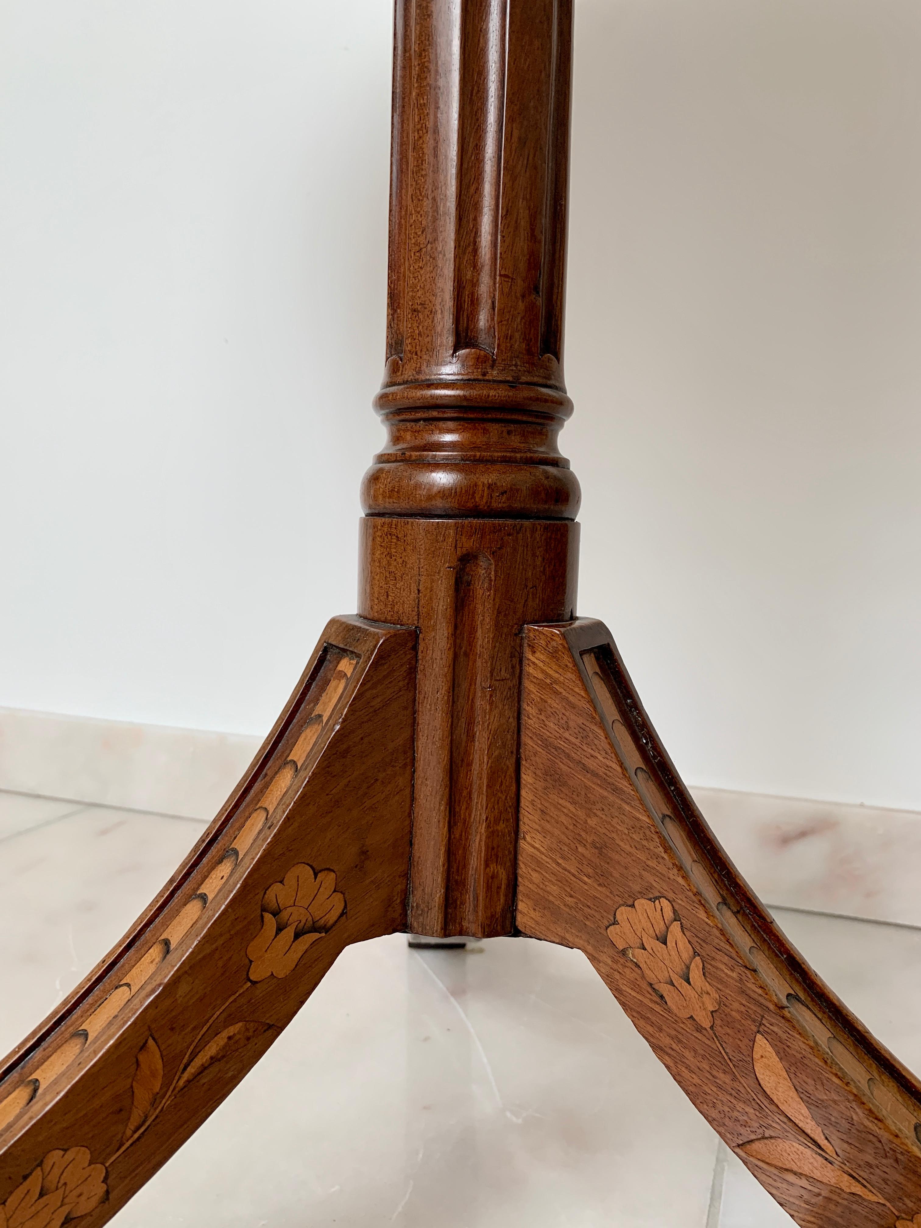 Very unusual marquetry tilt-top table, possibly Dutch dating from circa 1800. The legs with flower inlay, the top with silverware. The design of the marquetry is probably inspired by works of the famous Parisian cabinetmaker Charles Topino, yet the