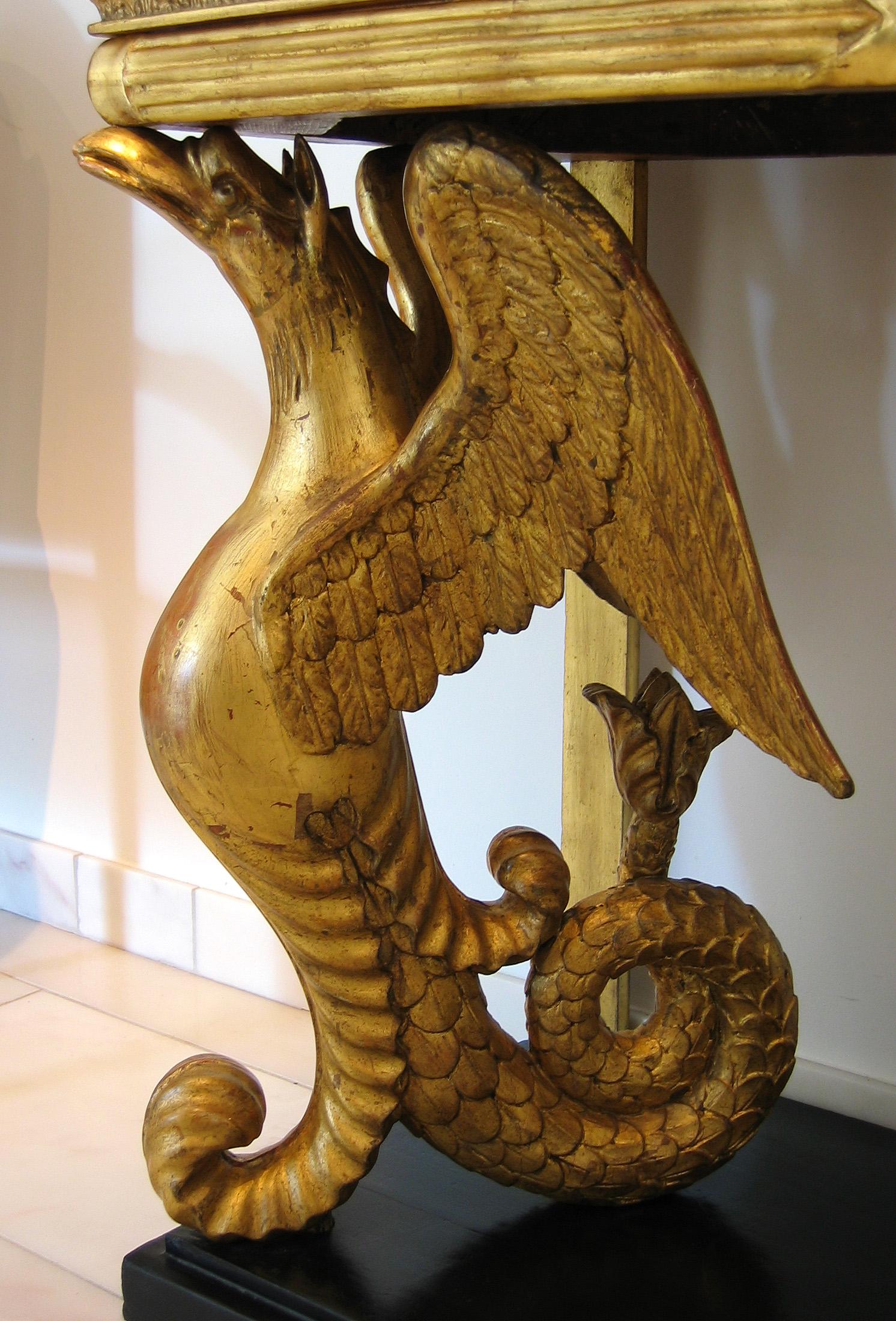 Ein sehr dekorativer und ungewöhnlicher schwedischer Konsolentisch aus vergoldetem und ebonisiertem Holz mit einer Platte aus weißem Marmor, die von zwei skulpturalen Greifen (teils Adler, teils Meerestier) getragen wird.
