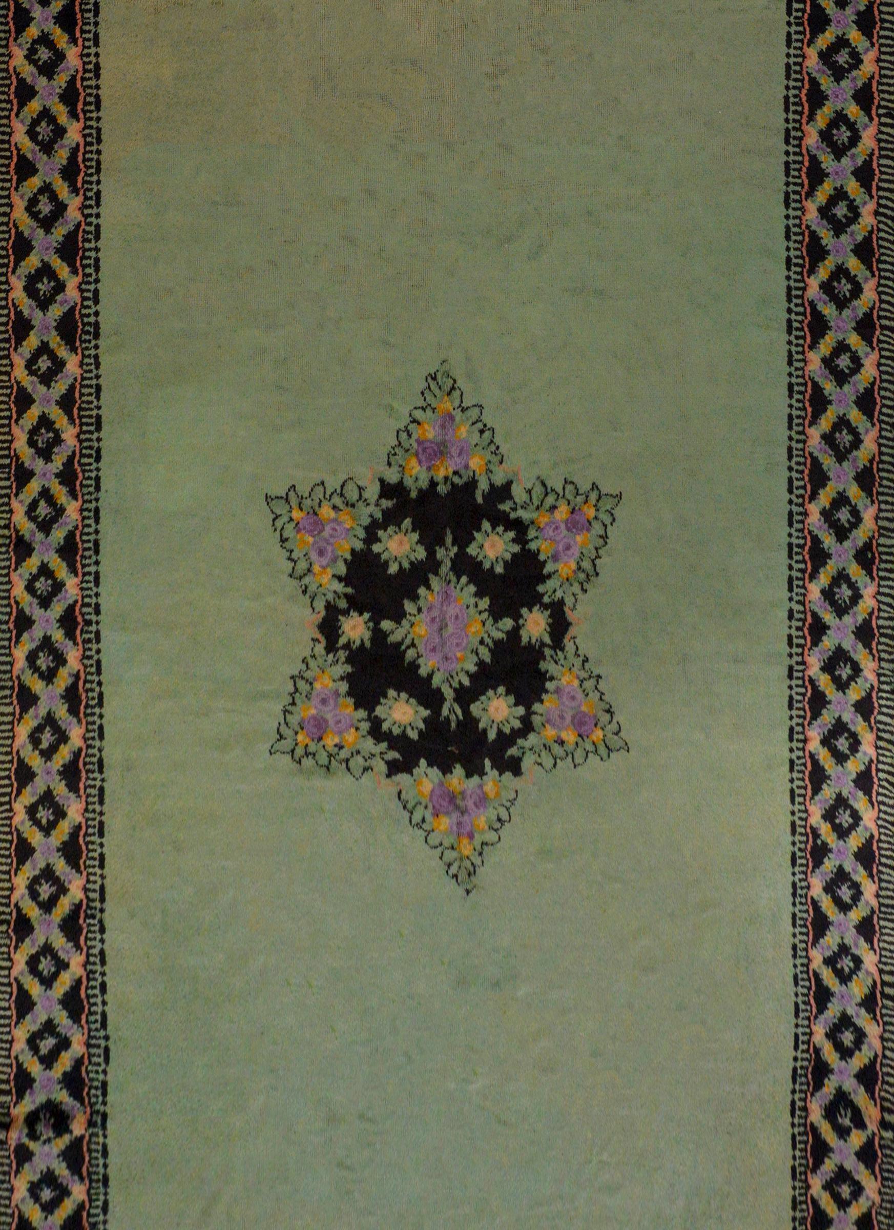 An unusual early 20th century Austrian rug with a large Star of David in the center formed from clusters of lavender and orange roses arranged in a garden pattern, on a wonderful solid mint green field. The border is styled with similar roses as the