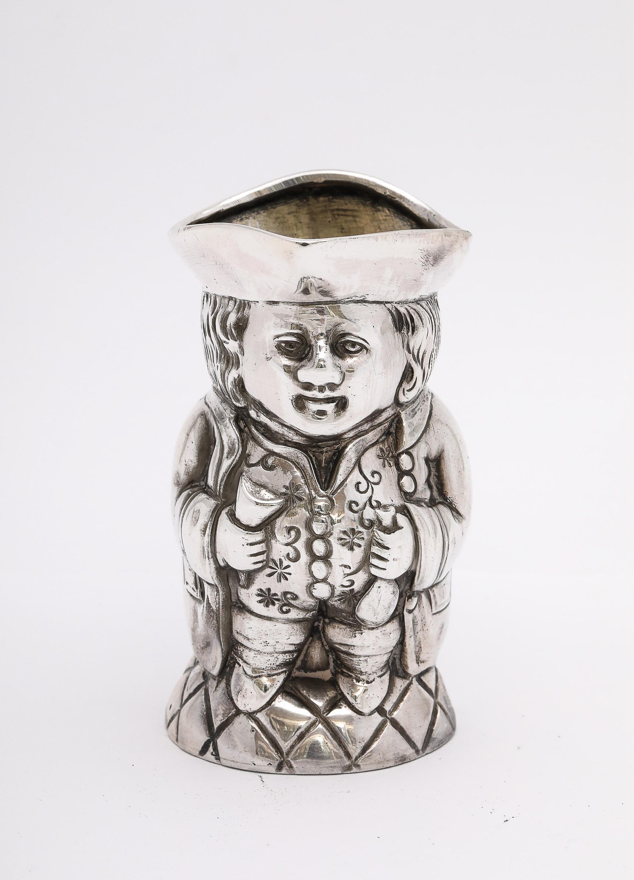Inusual jarra de crema en forma de taza Toby, de plata de ley, del periodo eduardiano, fabricada en Alemania e importada y reensayada en Londres, con matrícula de 1902, John George Piddington. La taza muestra ambos conjuntos de sellos. Muy bien