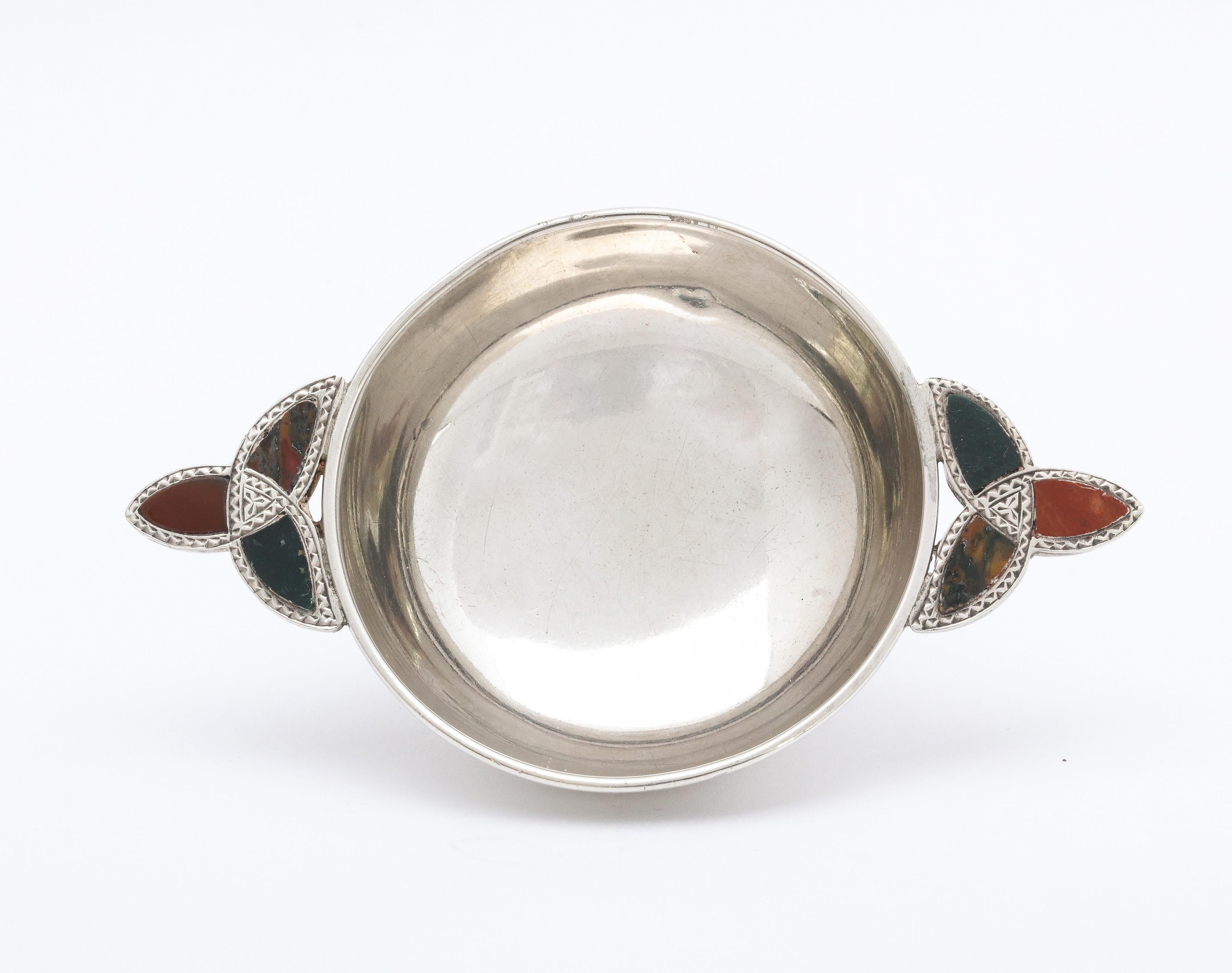 Unusual, Edwardian, sterling silver and Scottish agate small quaich (whiskey taster) on raised base, Birmingham, England, year-hallmarked for 1904. Measures 3 1/34 inches from outer edge of handle to outer edge of other handle x 1/2 inches high x