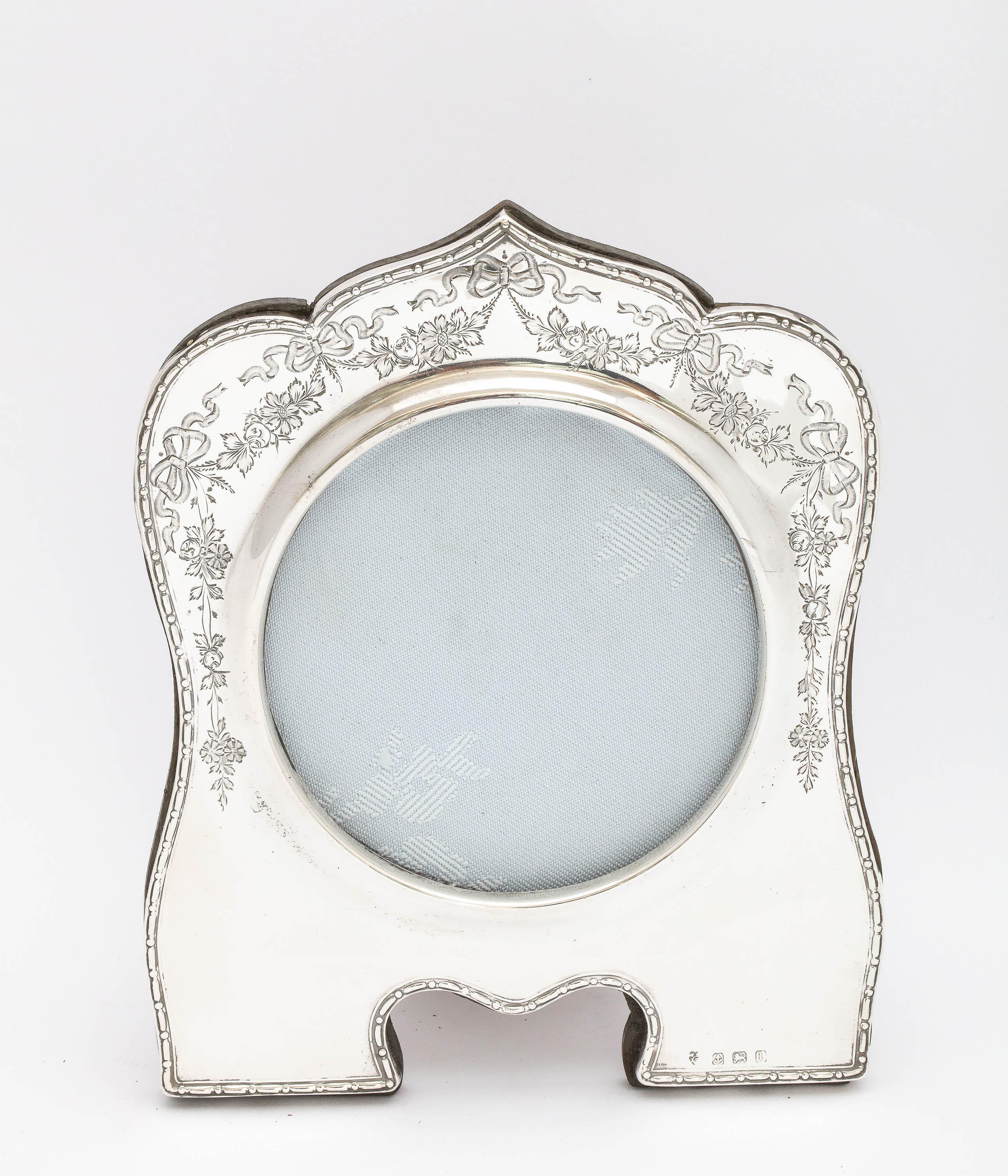 Cadre-photo édouardien inhabituel en argent sterling avec dos en bois, Birmingham, Angleterre, année - poinçonné pour 1910, Williams, Ltd. - fabricants. Décoré d'un joli travail de gravure - des guirlandes et des nœuds entourent la partie supérieure