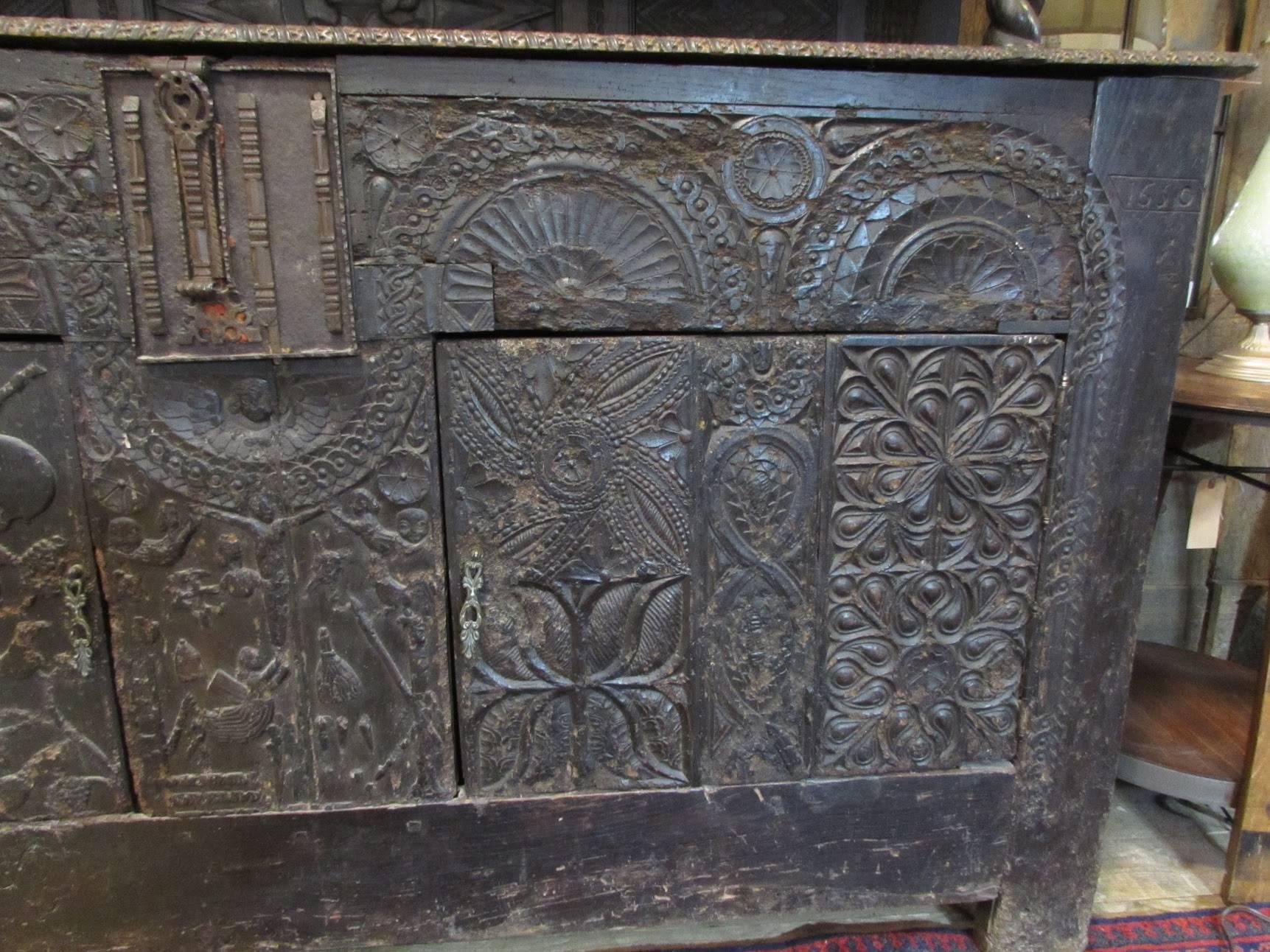 This English sideboard is heavily carved with figural Bishop and rabbit figures. Some original hardware, some replacement.

There are four large doors two on the top and two on the bottom, with fitted shelves. There are odd horizontal door on top