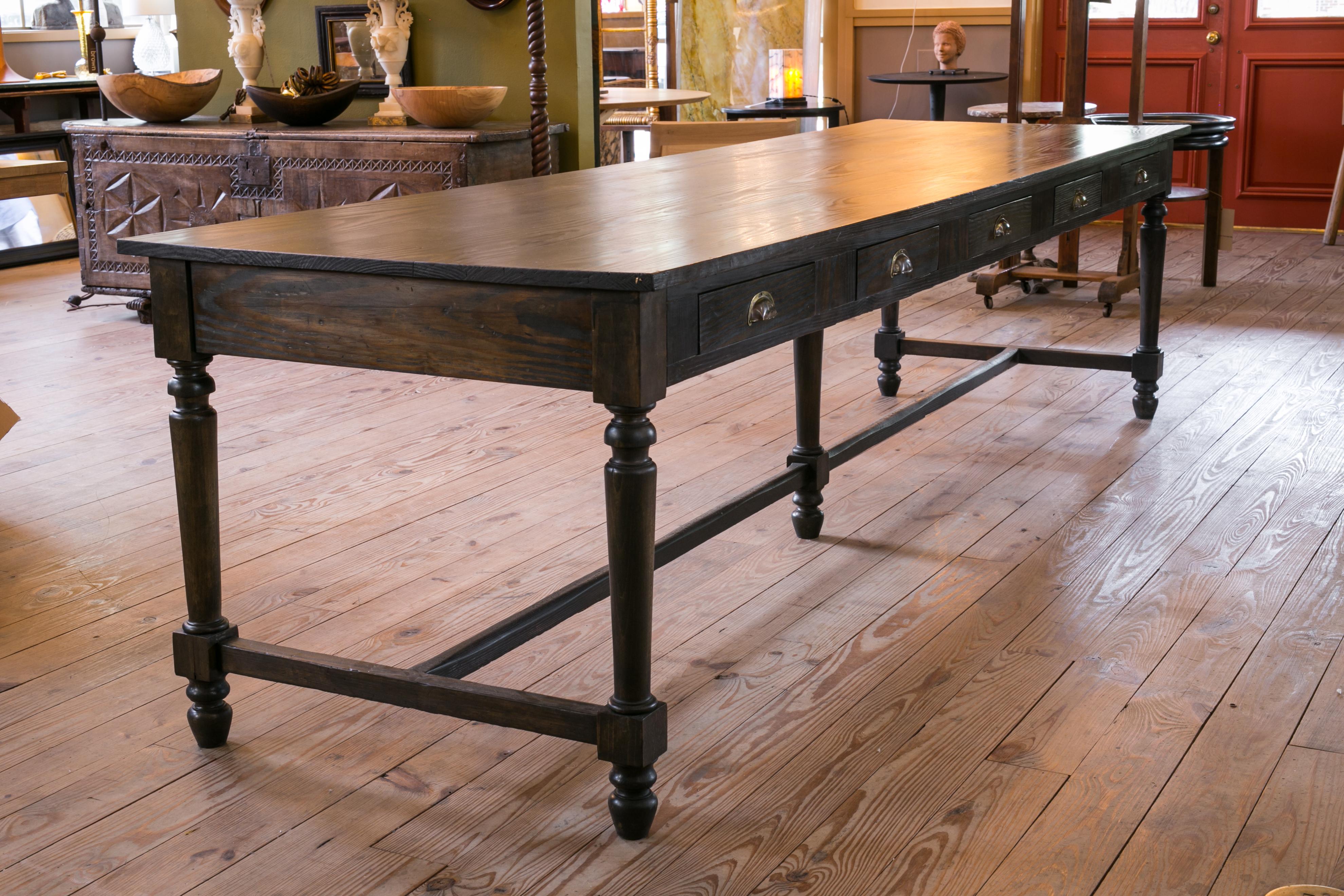 Unusually long country table of antique pine. This table is interesting and quite long. It has five drawers on each side and hails from a monastery. The grain of the wood is beautiful. The table is simple in shape and its drawers could be fun for