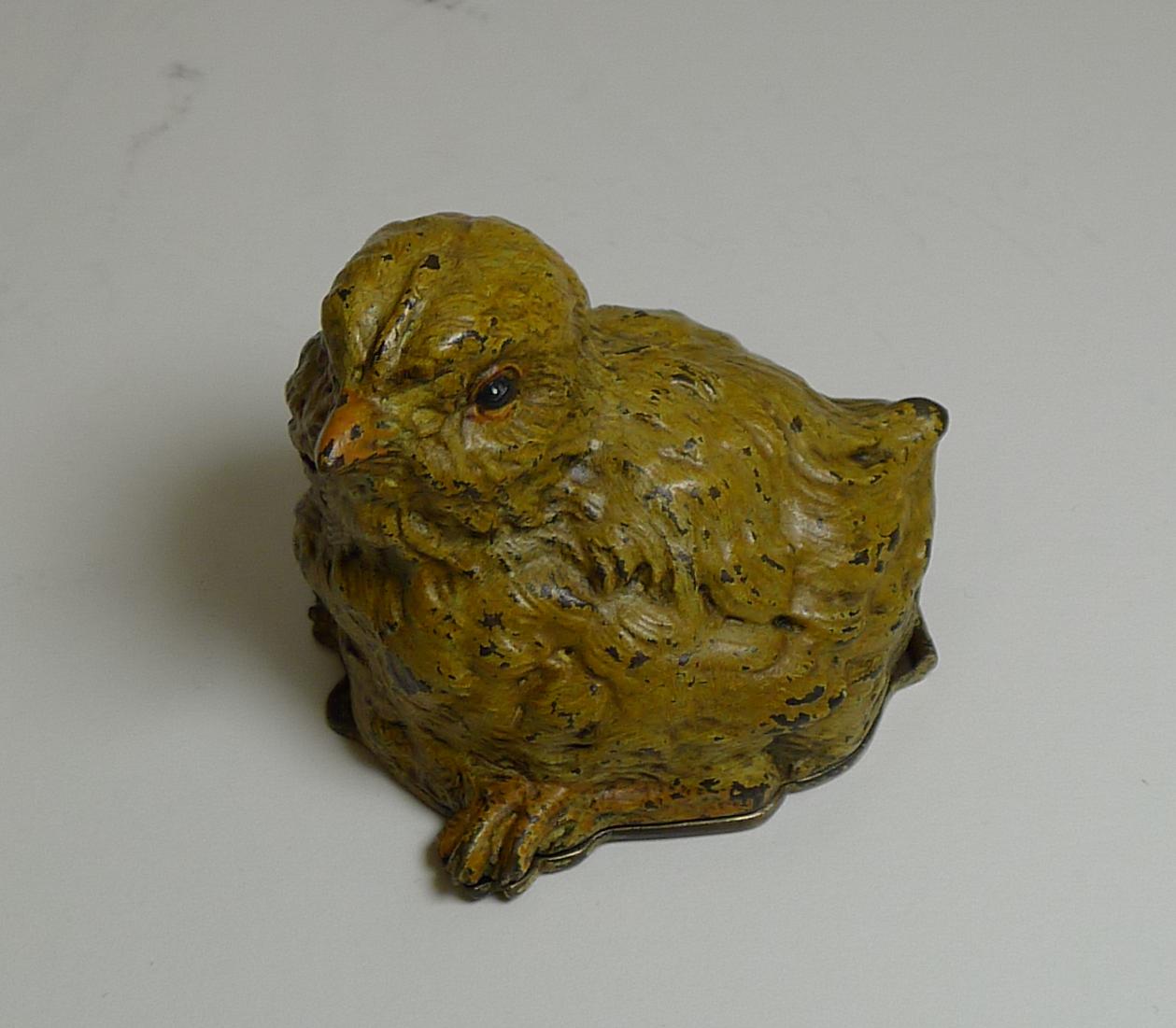 A charming and very unusual novelty postage stamp box in the form of a chick, cast in bronze and cold painted.

The hinged lid lifts to reveal a single postage stamp compartment with a sloped interior to easily slide out the stamps, a little catch