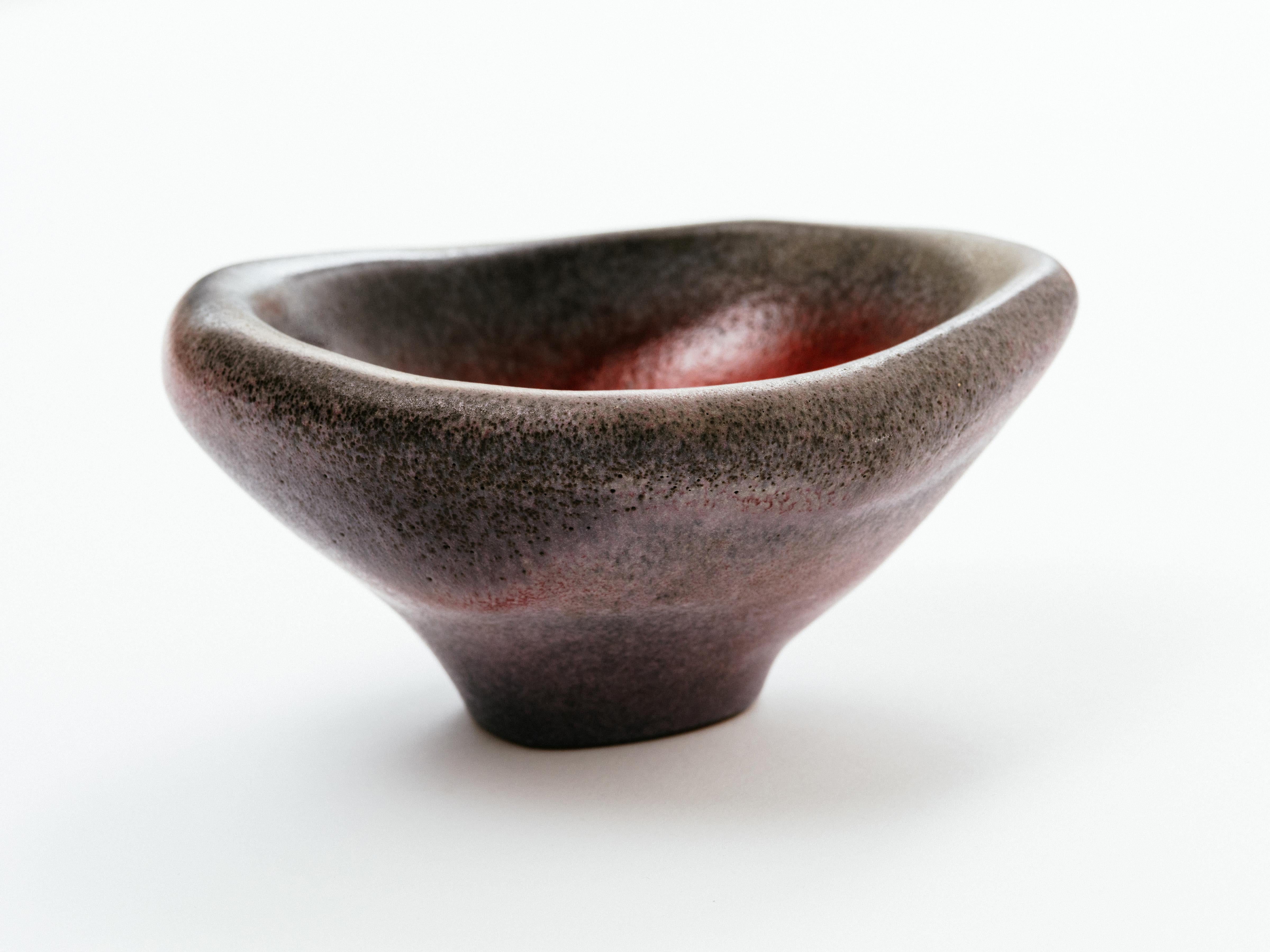A striking and highly unusual slip cast ceramic vessel in a rather complex matte, gray glaze that nearly resembles stone, finished with an intense glossy red glaze to the interior. Czech, 1960s.