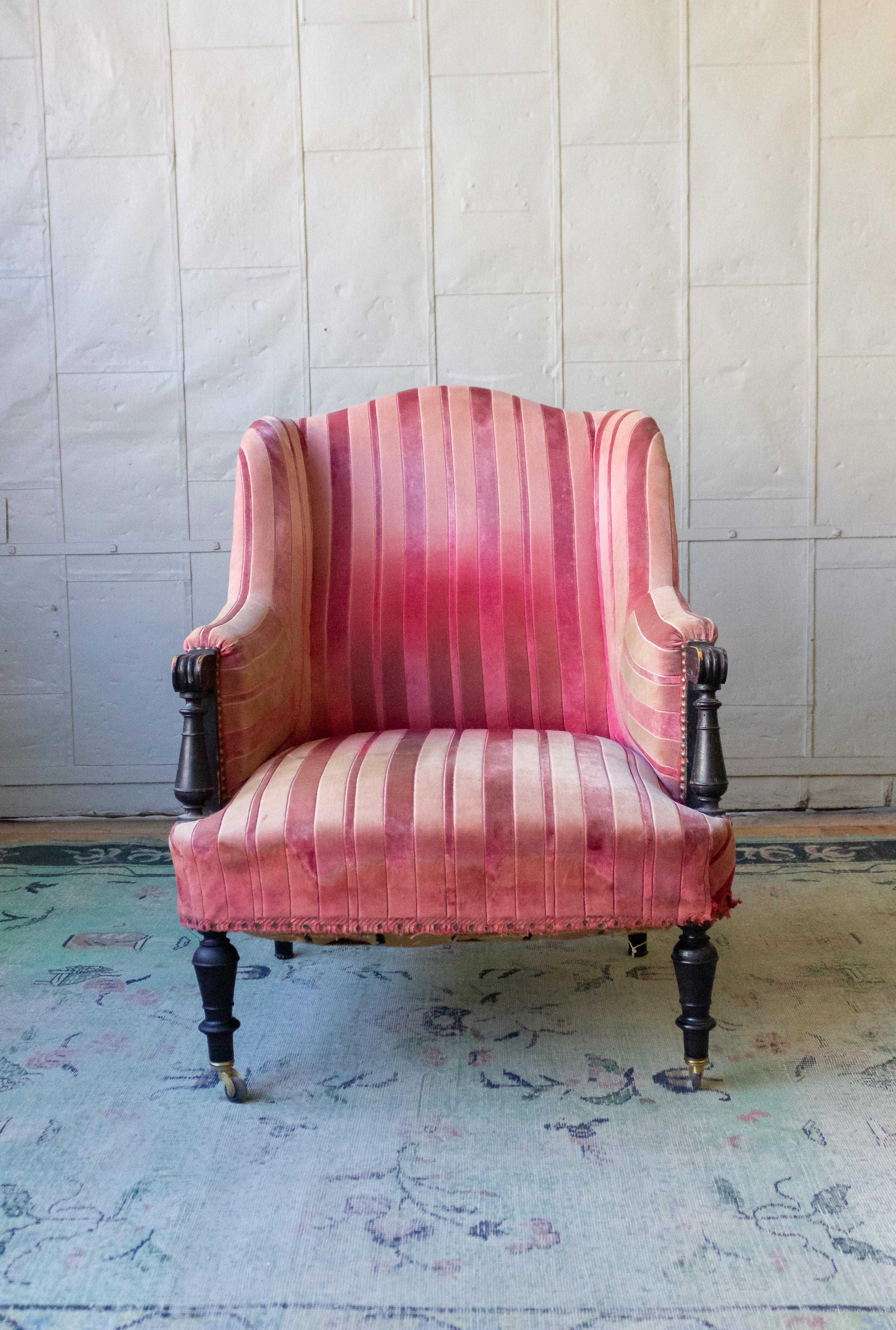19th century Napoleon III armchair with wooden arm and faded striped velvet.