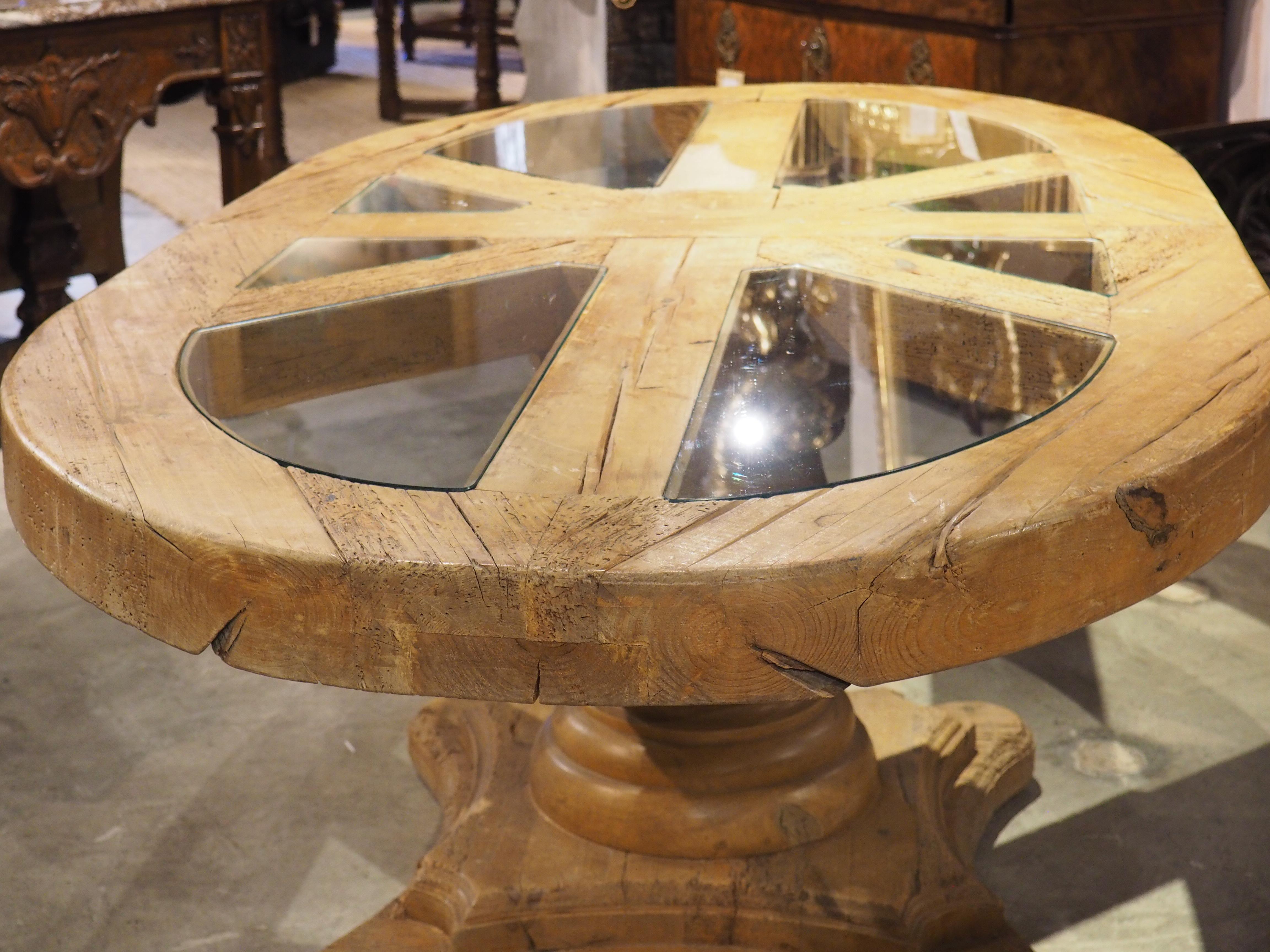 Cette table de salle à manger ou de petit déjeuner est un objet insolite et fascinant provenant de France, vers les années 1940. Elle comporte huit panneaux de verre insérés dans le plateau de 3 ½ pouces d'épaisseur, qui sont disposés en forme de
