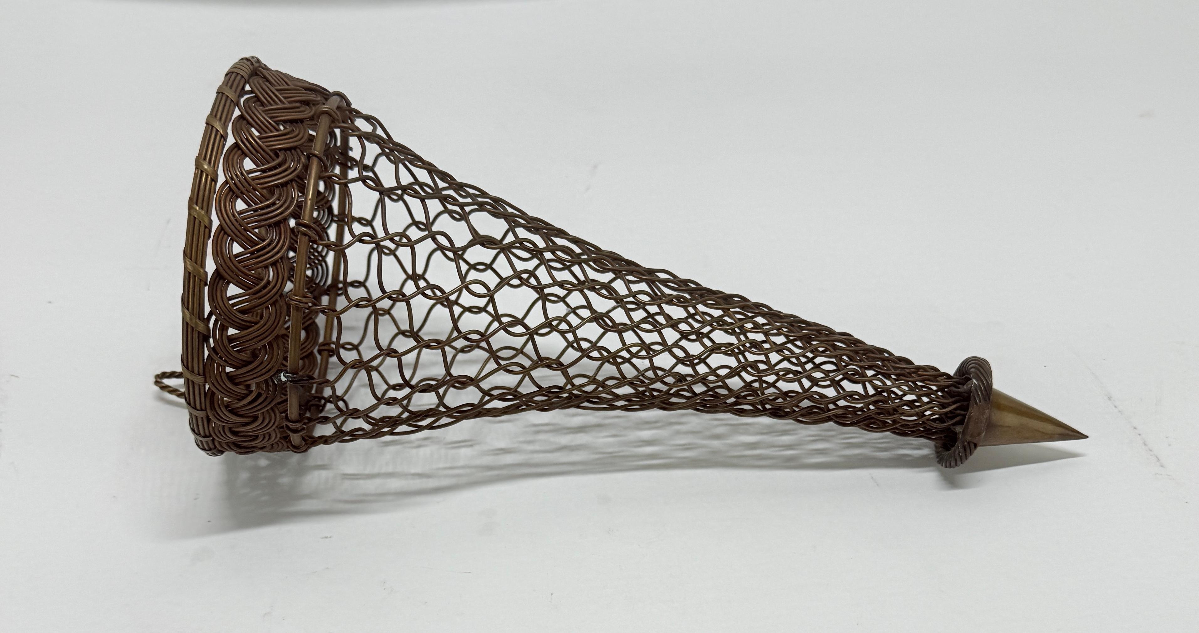 An unusual and finely executed hand-wrought bronze wire wall pocket or bouquet holder, dating to the late 19th or early 20th century, of likely French origin. The form comprises a long tapering cone woven from interlaced bronze wire, terminating in