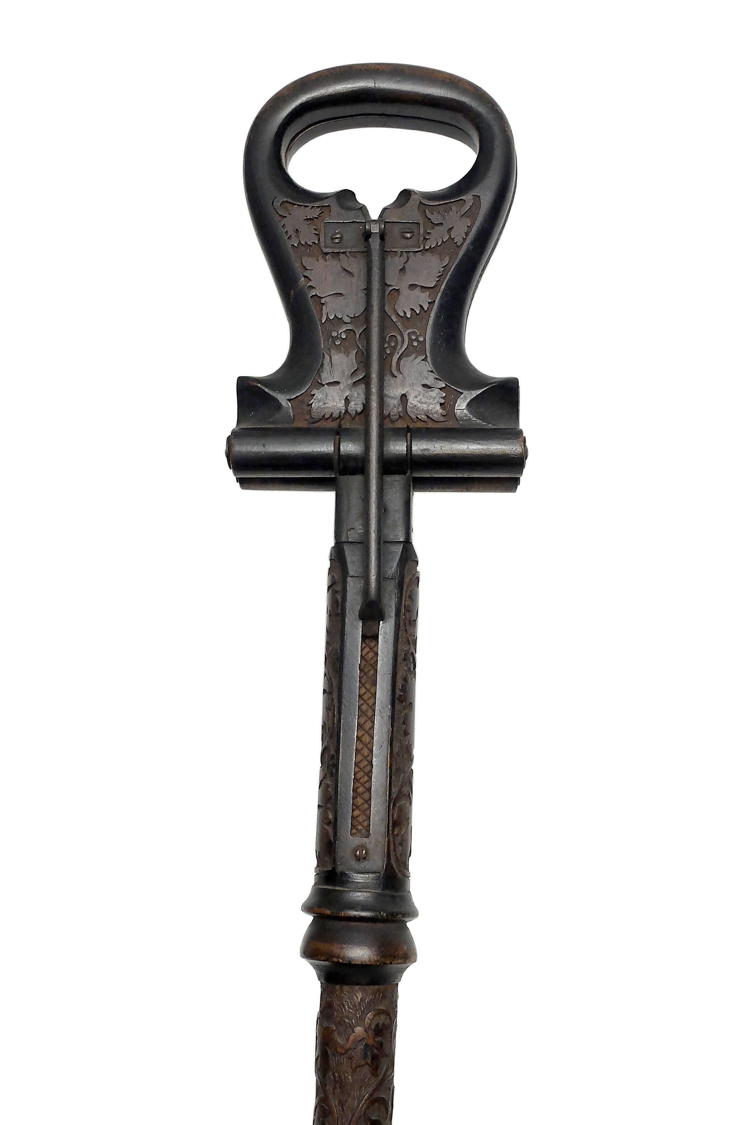 This cane is an unusually and richly decorated sample of the famous seat gadget cane. Tall iron ferrule with a wide disk to stop and secure it when plugged into the grass, the shaft and the openable handle are entirely engraved in low relief with a