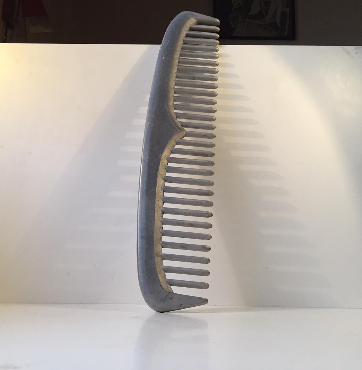 A large unique comb that hang outside a Barbershop in Esbjerg, Denmark. From circa 1950-1980. It is made from solid aluminium and is a rather precise and detailed imitation of the vintage aluminium comb for beard and hair.