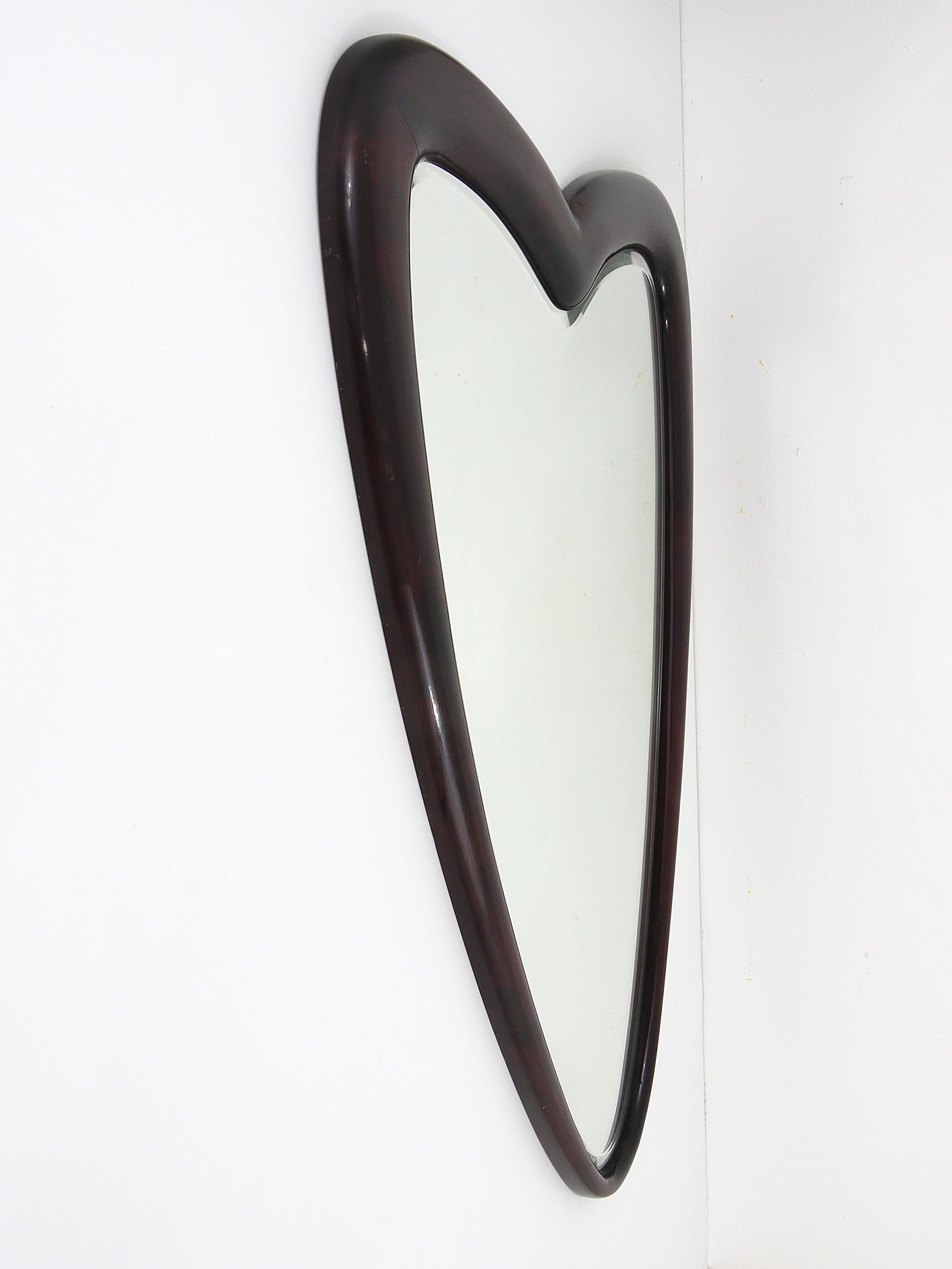A beautiful, big heart-shaped wall mirror. Made in Italy in the 1940s, has a facetted mirror glass and a frame made of dark wood. A very elegant Italian mirror in very good condition. Measures : 27x39