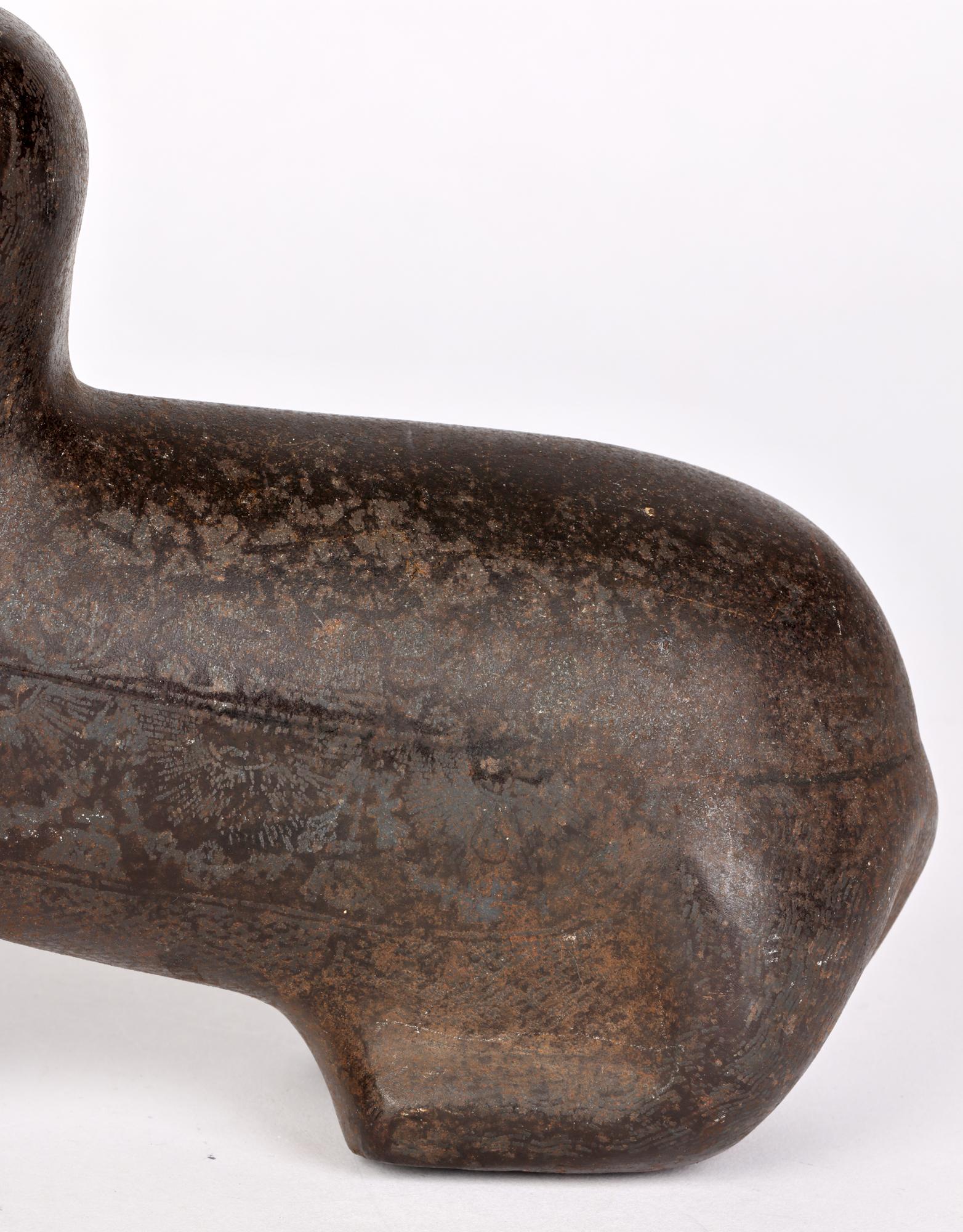 Une inhabituelle tribu indienne des Khond antique/vintage attribuée à la sculpture de chien assis en métal patiné stylisé, probablement en bronze, que l'on pense dater de la fin du XIXe ou du début du XXe siècle. Le chien est très simplement formé,