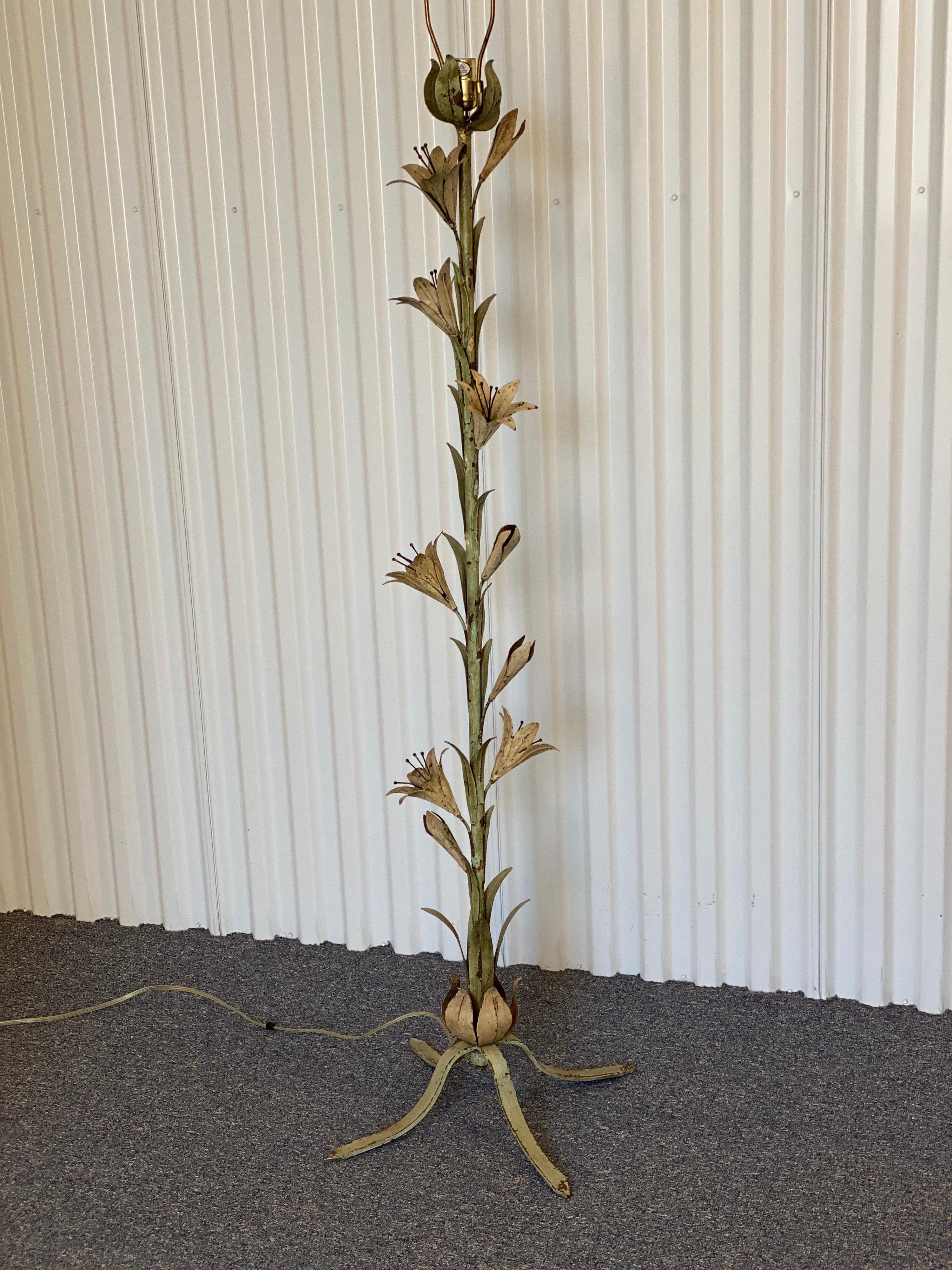Unusual iron standing lamp with green leaves and cream lilies. Great wear and patina.
Measures: 55.5” high x 19.5” wide x 19.5” deep base 
10” wide lily projection at widest point.