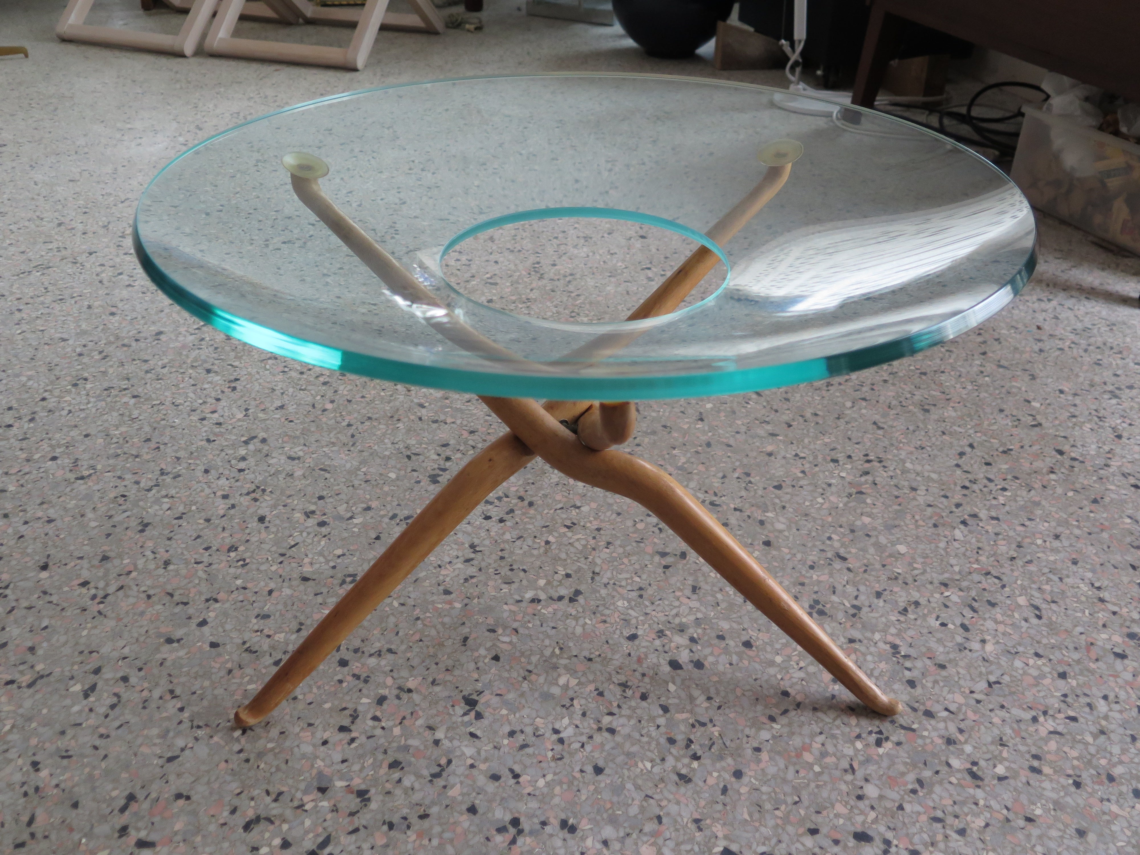 Insolite table moderne organique italienne avec un plateau en verre découpé. Les pattes se plient, le verre est épais avec une teinte verte.