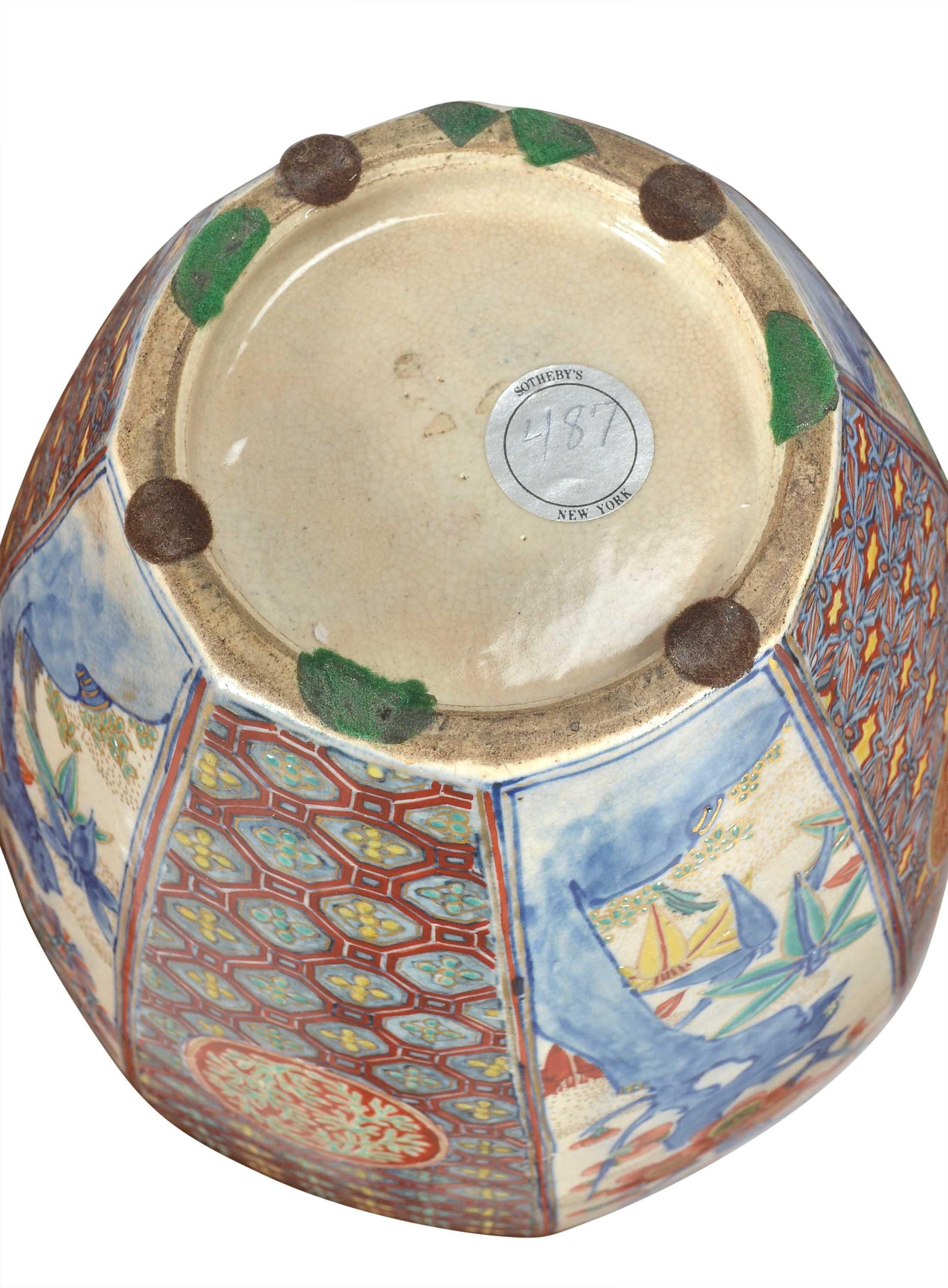 Eine japanische Imari-Vase von ungewöhnlicher Form und Farbgebung. Der Vasenkörper ist in acht blütenförmige Abschnitte unterteilt, die abwechselnd mit Blattwerk auf hellem Grund und geometrischen Mustern verziert sind. Mit einem ungewöhnlichen