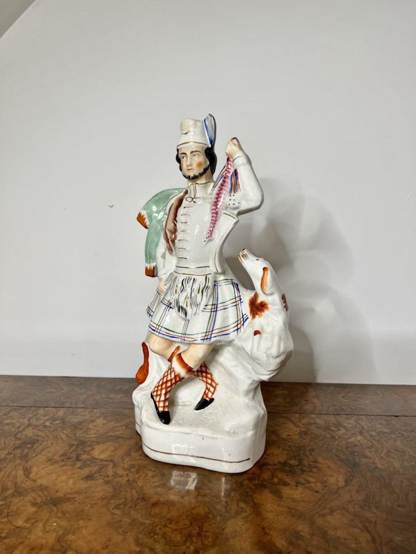 Unusual large antique Victorian Staffordshire figure of a Highlander in traditional clothing with his dog to his side holding a bird in one hand, rabbits to the other side and a hunting gun, hand painted in fantastic white, blue, green, red and gold