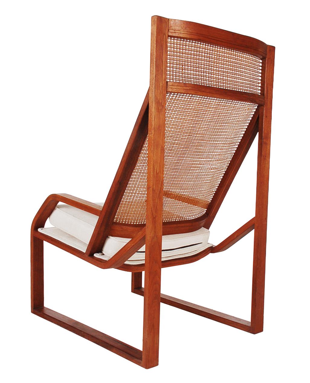 A very neat larger scale high-back lounge chair from Scandinavia circa 1960s it features a high back solid teak frame, cane backrest, and upholstered seating area.