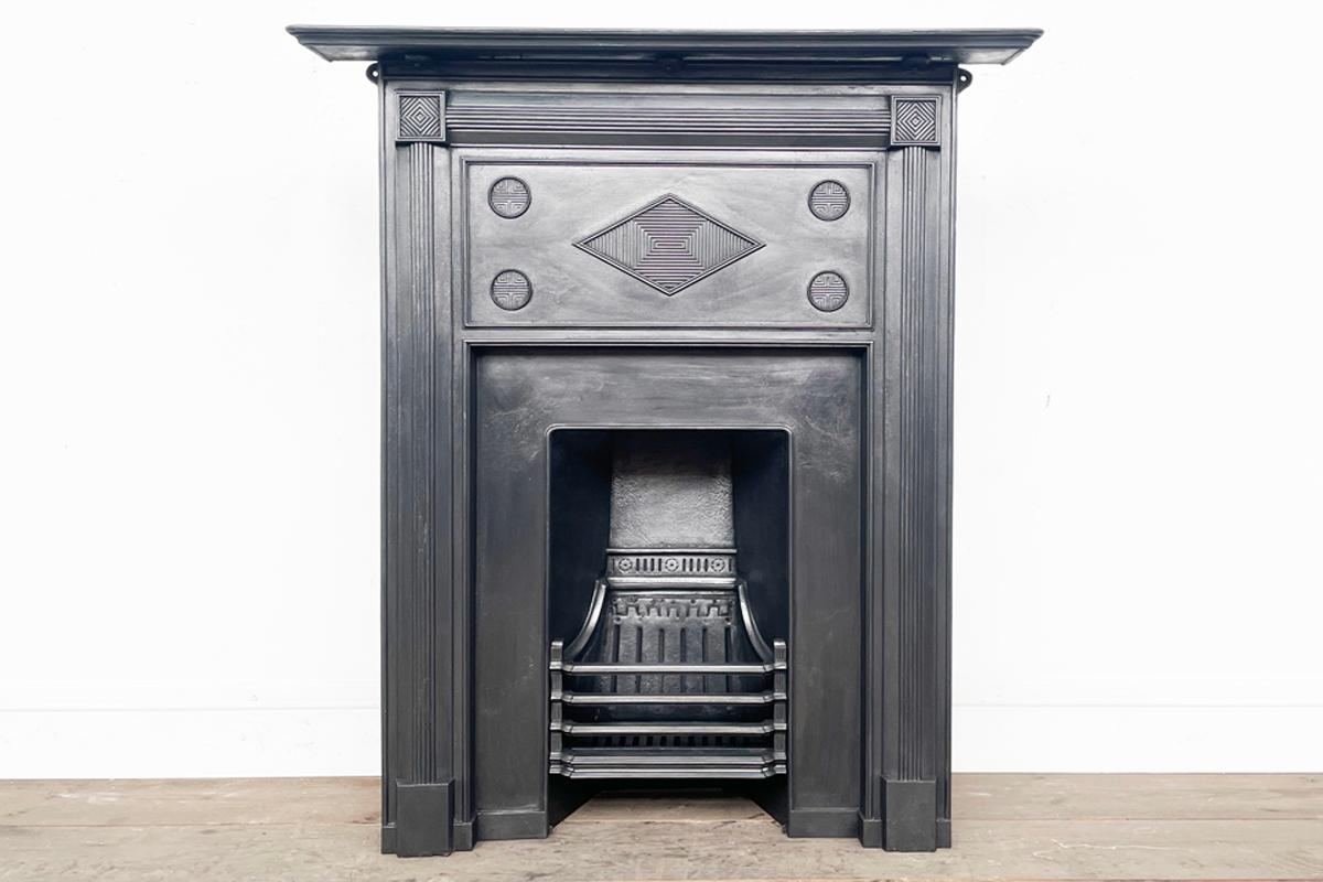 Unusual late Victorian cast iron combination fireplace with an almost Art Deco feel. The deep frieze is decorated with a central diamond anel inset with geometric lines and 4 discs also with geometric lines within. The whole is framed by reeded