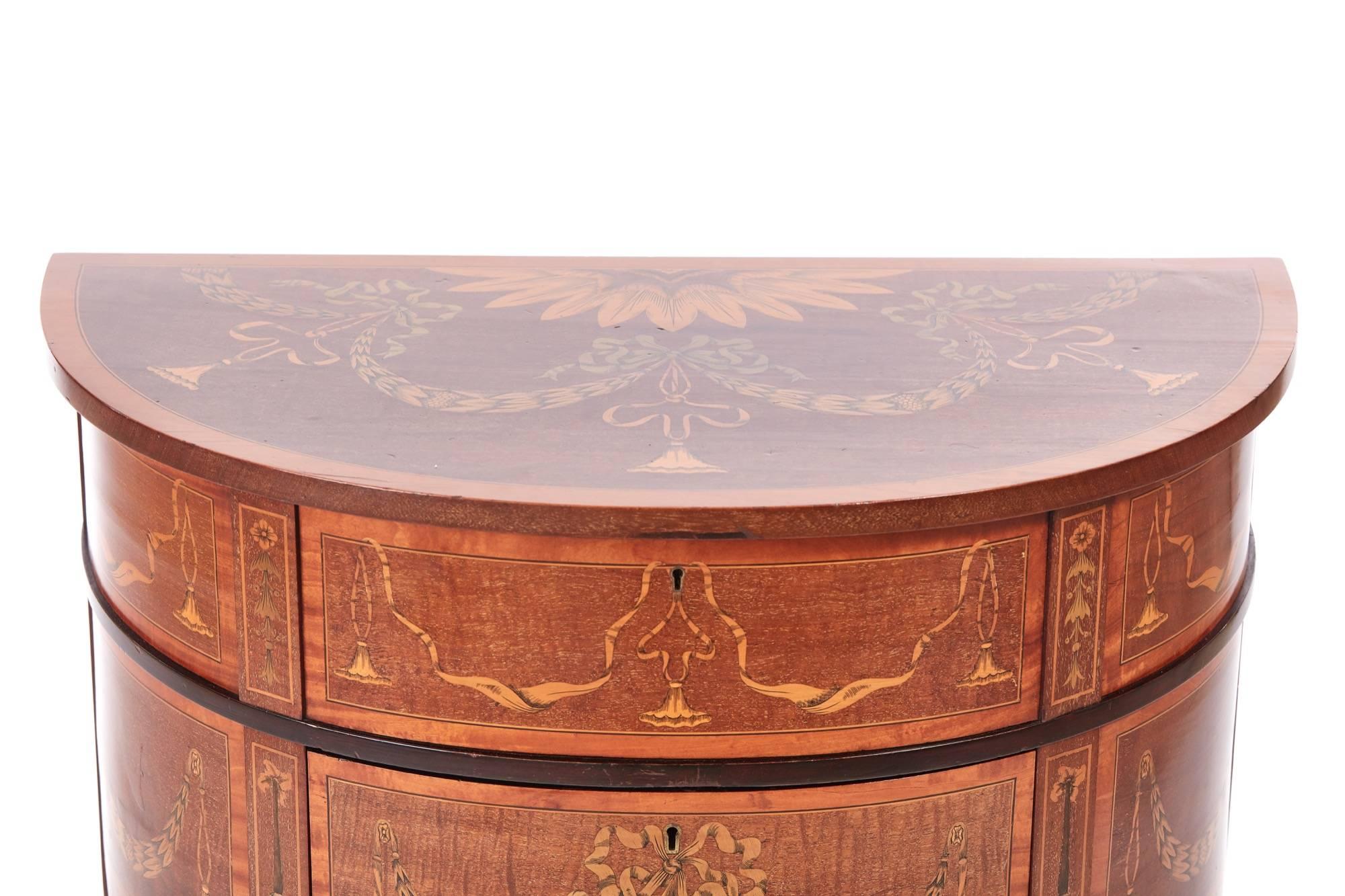 Unusual mahogany inlaid Edwardian demilune side table, having a fantastic marquetry lift up top with ribbon and swags inlaid detail, cross banded in satinwood, the frieze again inlaid with ribbon and swag, supported on elegant inlaid square tapering